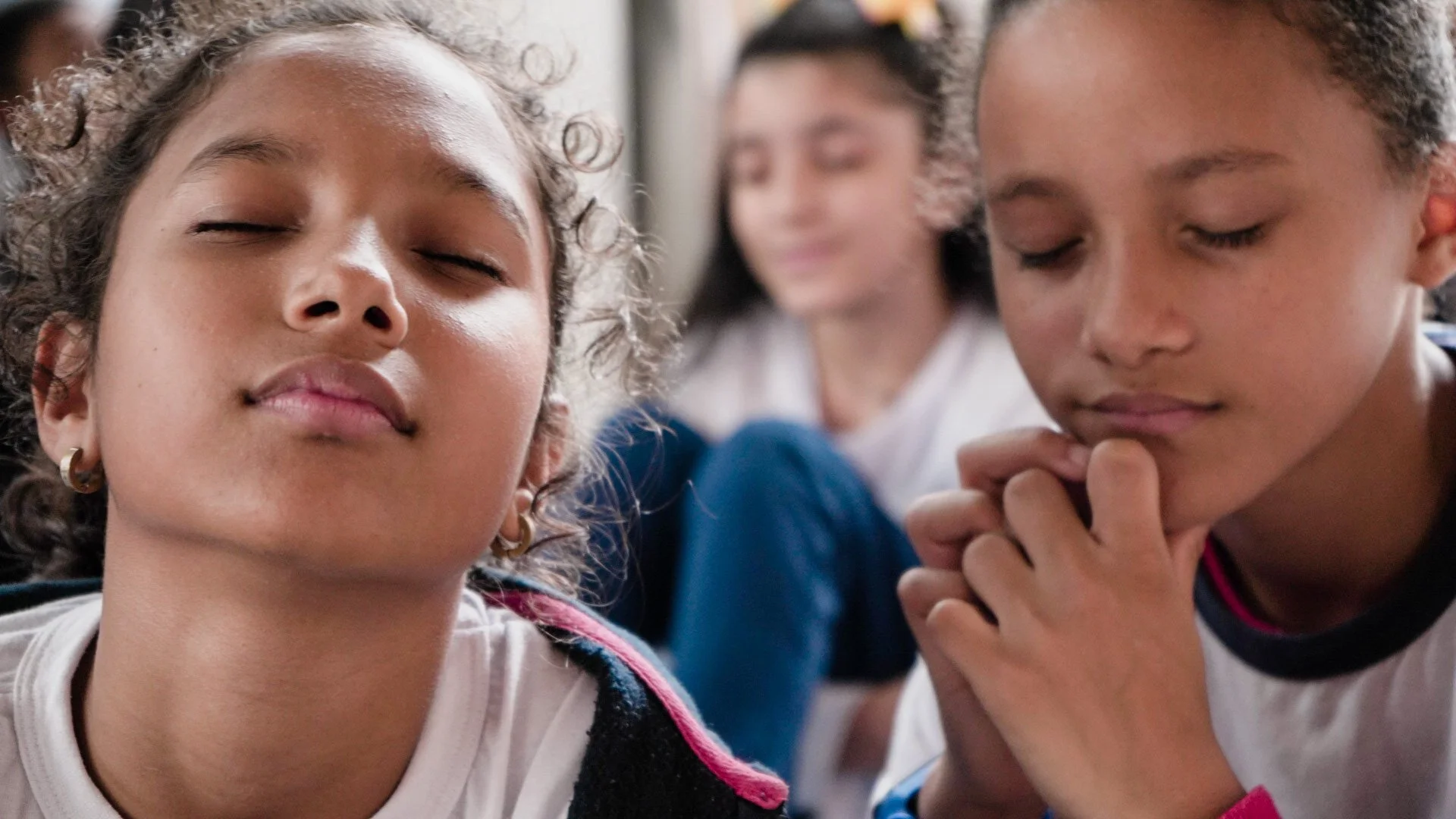 Mãos de uma mulher vistas de cima, esfregando especiarias aromáticas na carne crua no papel-manteiga