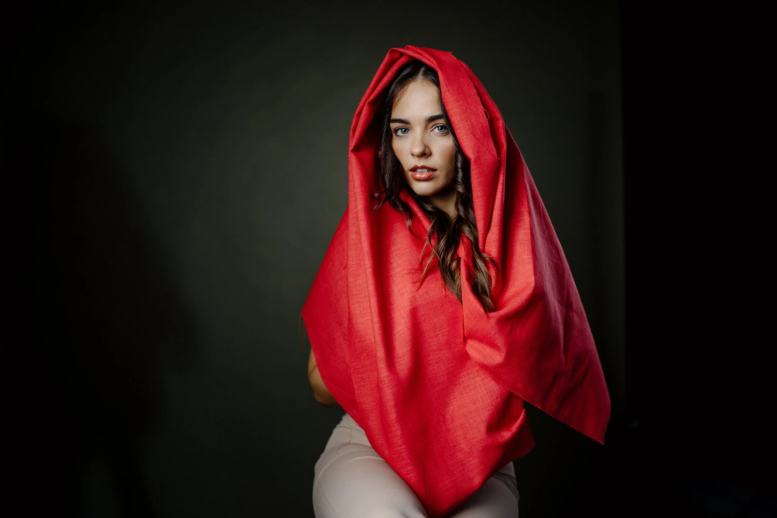 Erin Hobden looking to camera from under a red hood