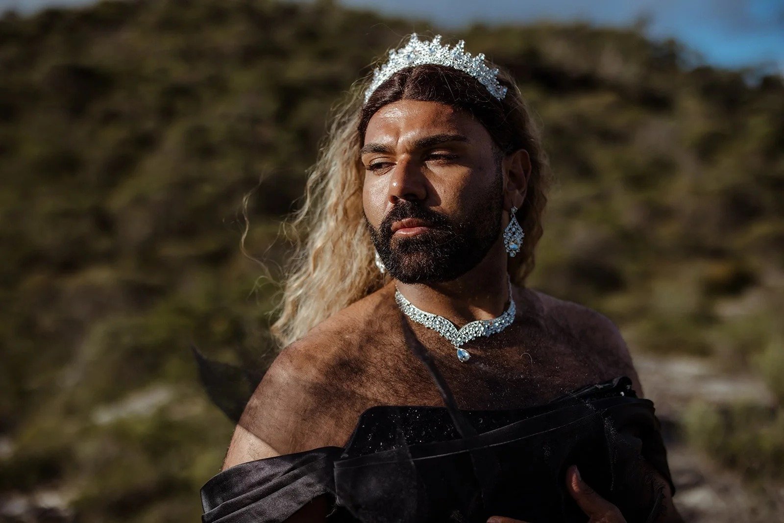 Dylan "Shaede" Hoskins in a tiara and diamonds, mountains behind
