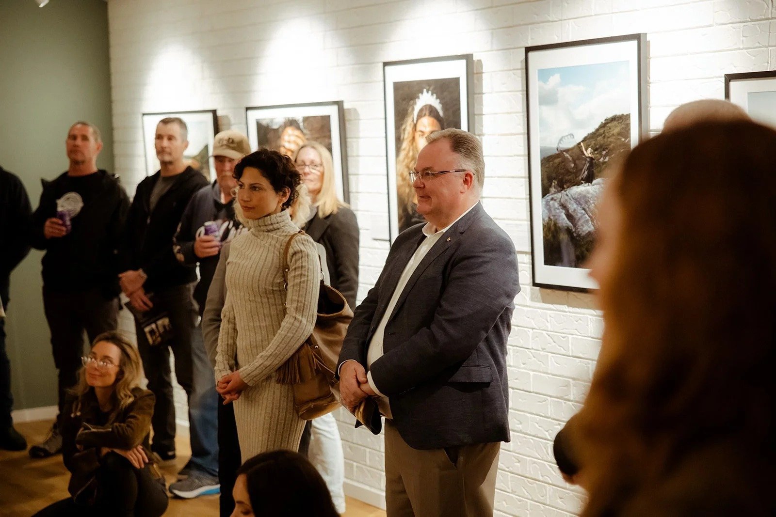 Visitors among the portraits at The Next Generation exhibition, Heart Space Copa