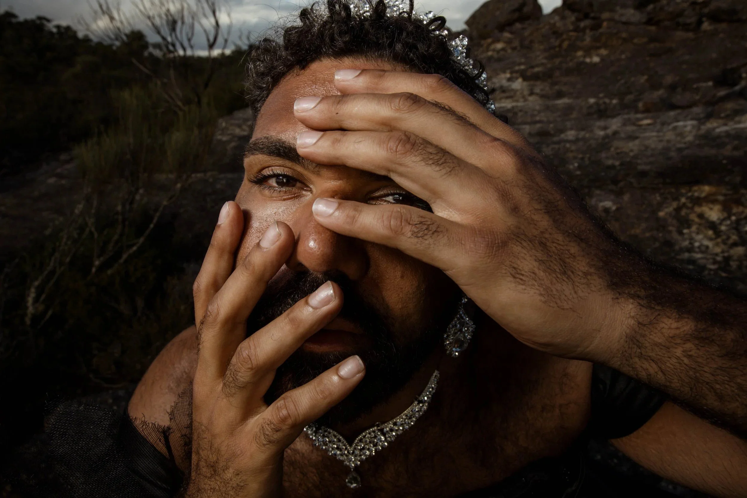 Shaede with both hands across the face. The Shaede Project, 2025