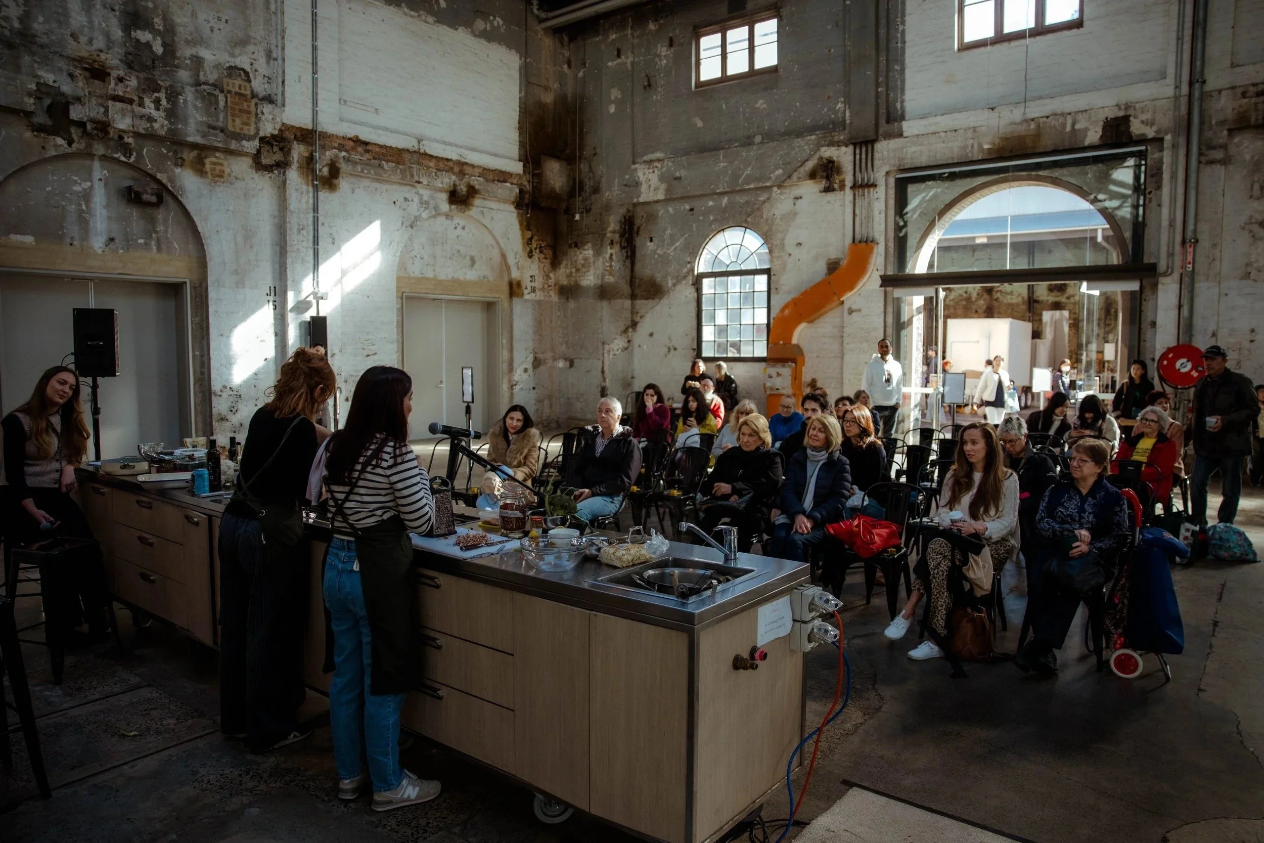 A cooking demonstration in the hall at the Carriageworks Winter Seasonal Market