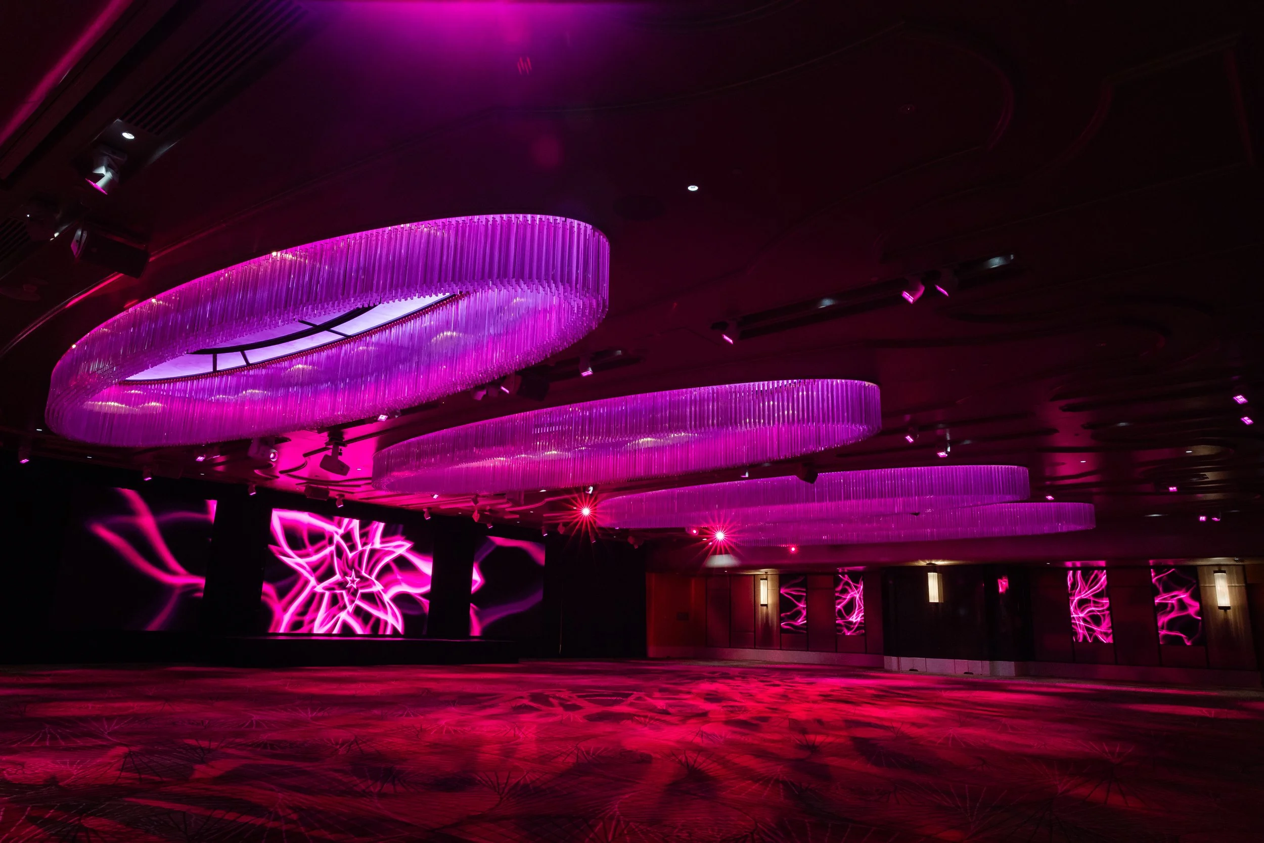 The Grand Ballroom at Shangri-La Hotel, Sydney in magenta light, with graphics on the stage screens