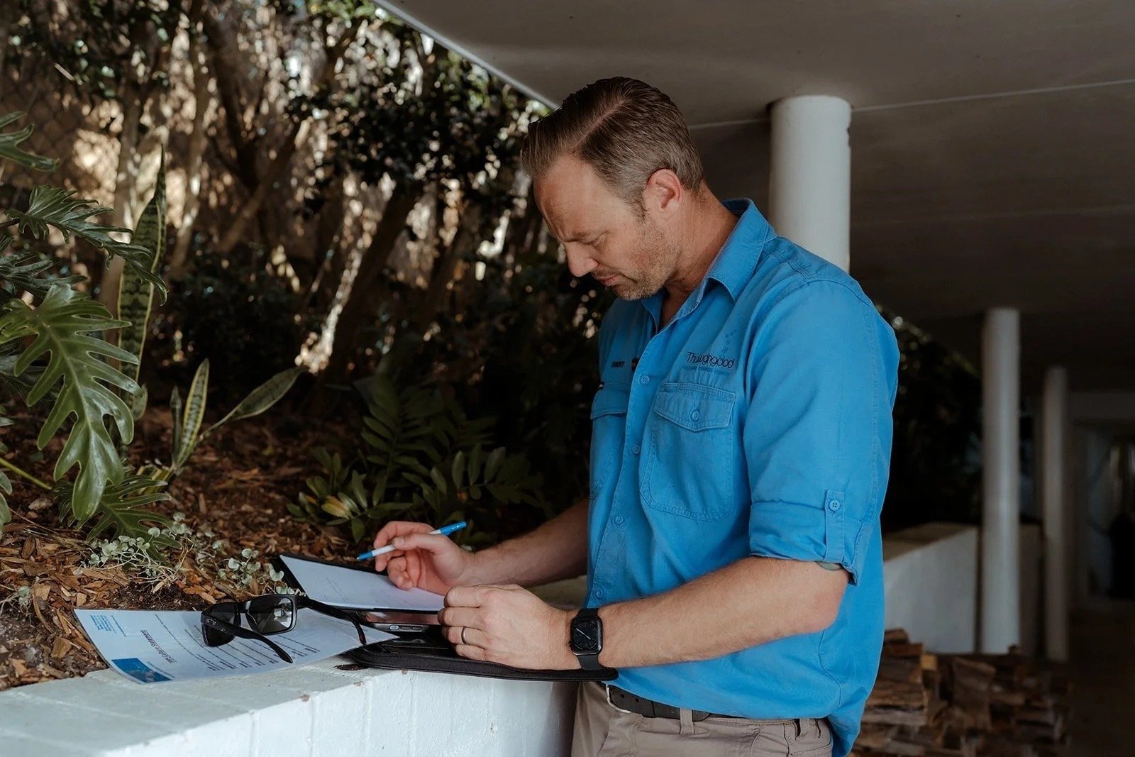 A Thoroughgood Plumbing plumber writing up a job on a clipboard