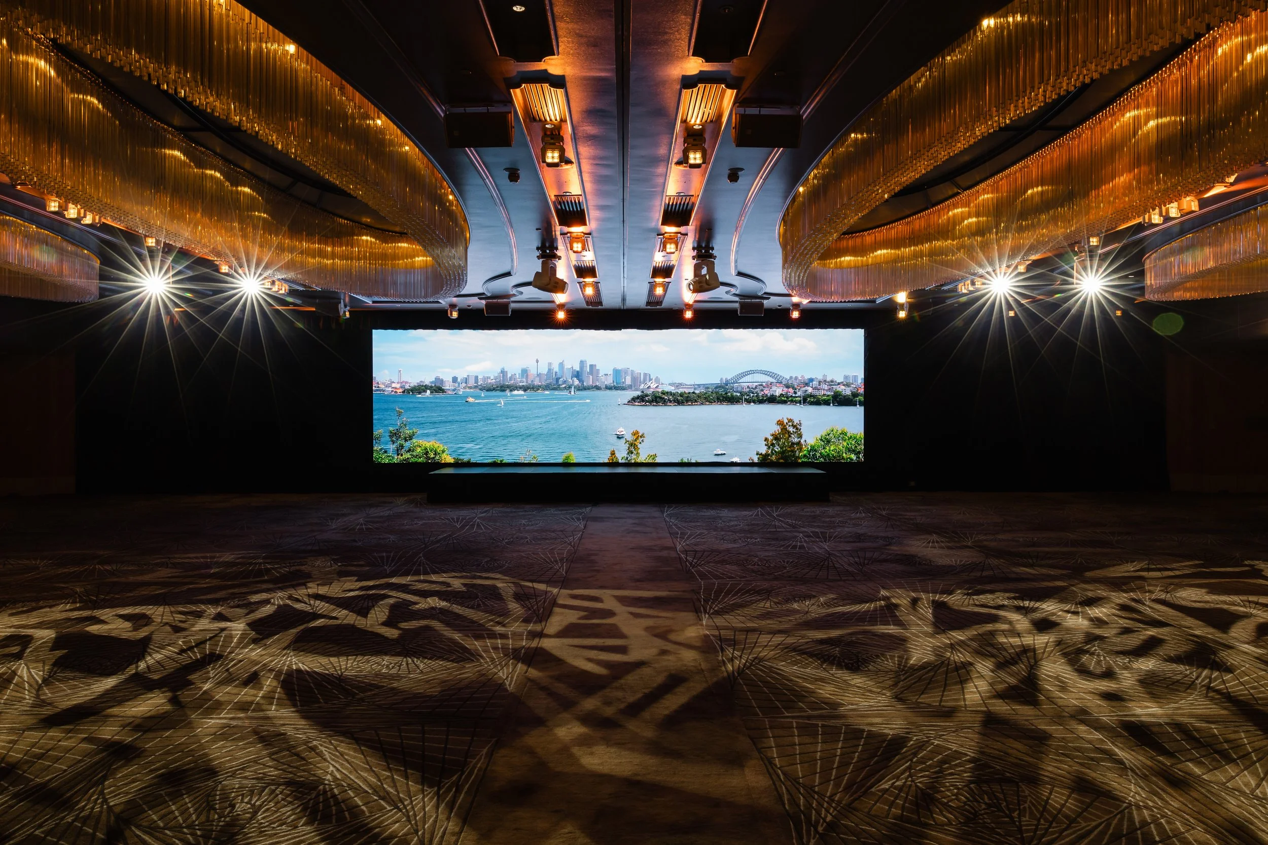 The Grand Ballroom at Shangri-La Hotel, Sydney with the stage lit under the chandeliers