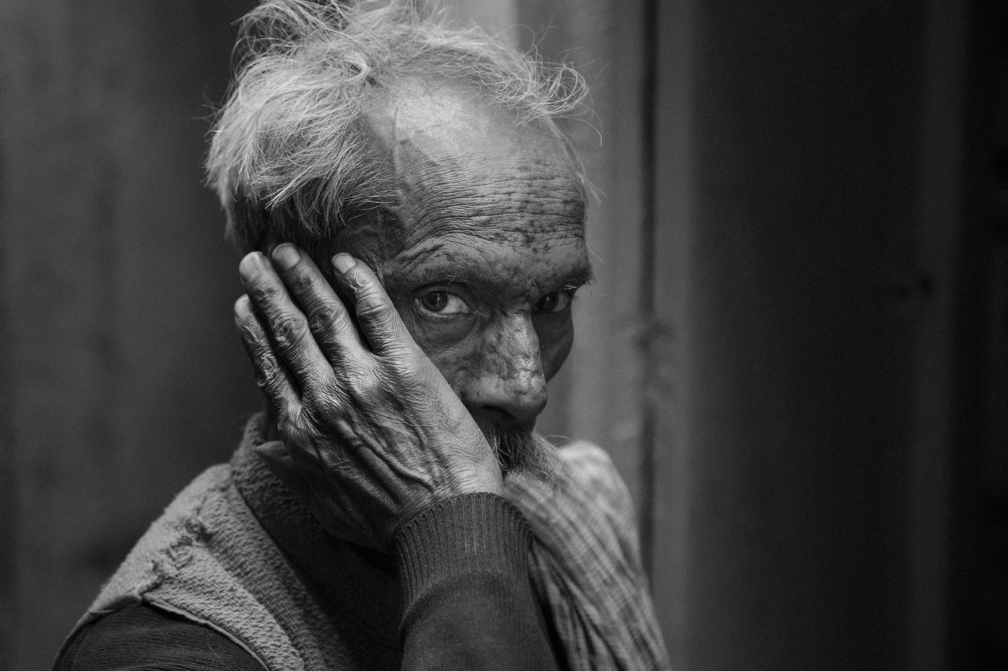 Black and white portrait of an elderly man with his hand to his face, Rajasthan