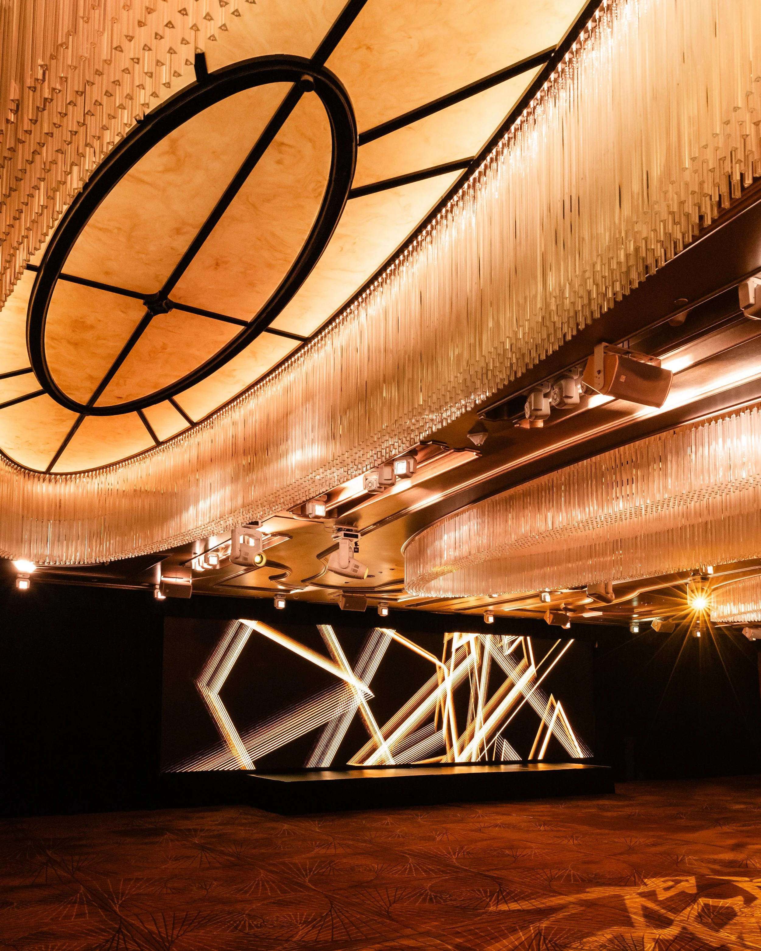 The Grand Ballroom at Shangri-La Hotel, Sydney in warm light, with white effects lighting on the stage