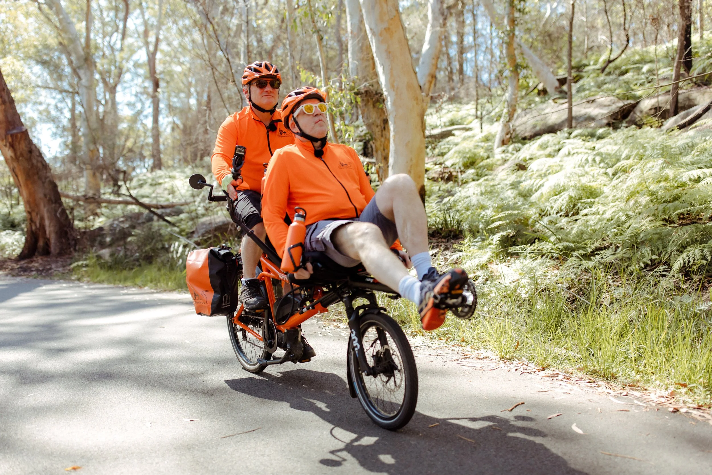 The Riding Together tandem climbing a bush road through the gums