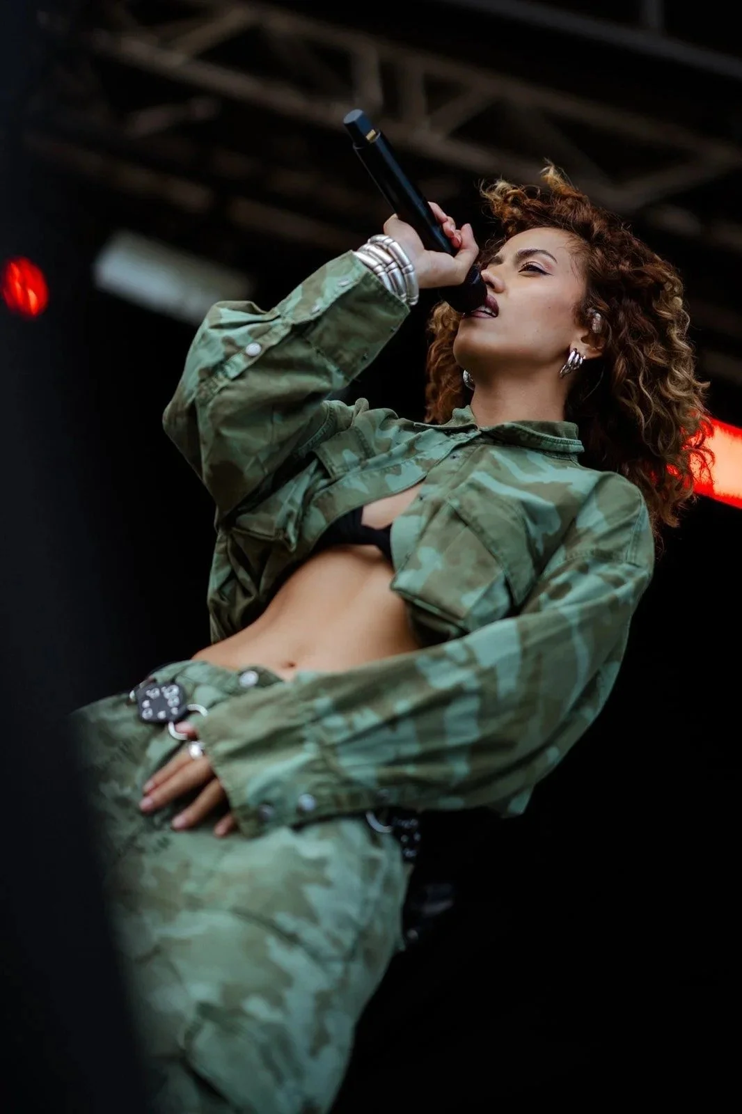 A singer in a green outfit performing on stage at Yours and Owls Festival, Wollongong