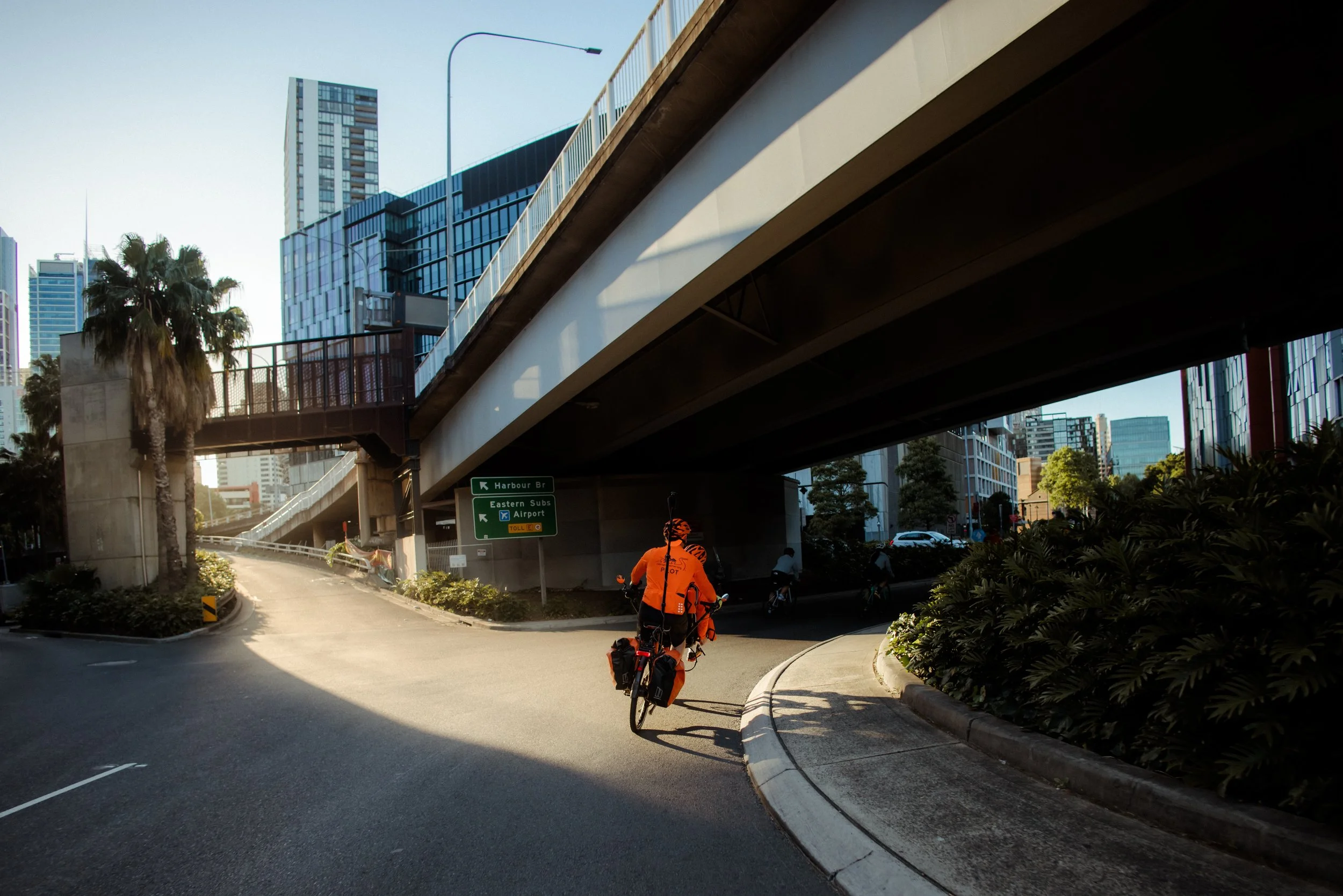 A Riding Together tandem passing under a city flyover during Spring Cycle, Sydney