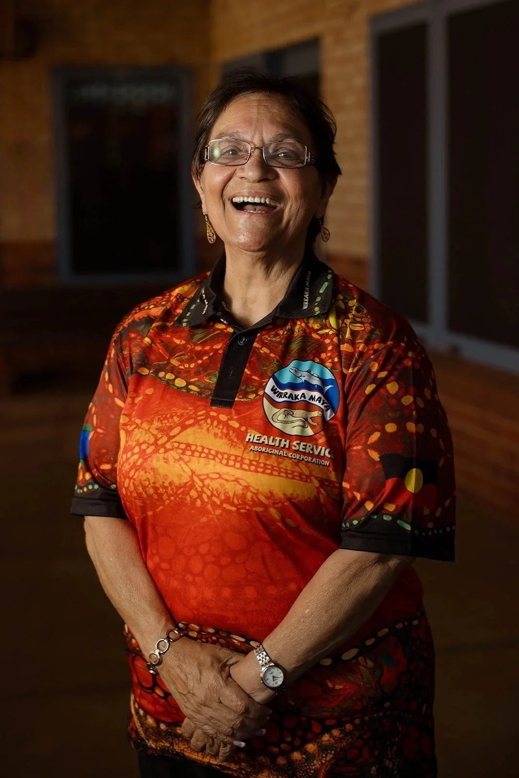 A Wirraka Maya Health Service staff member laughing in her uniform shirt, Port Hedland