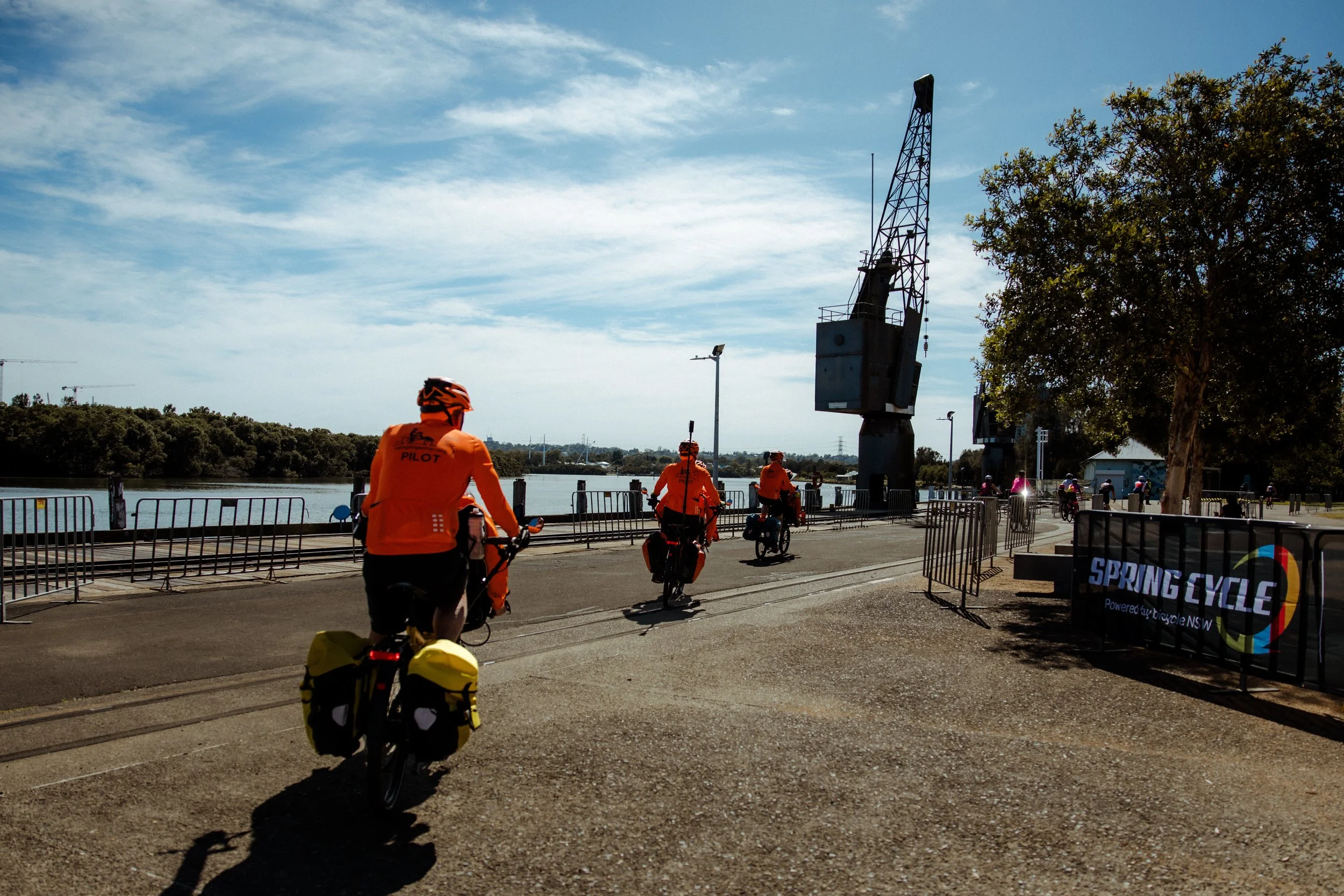 Riders crossing the Spring Cycle finish by the water in Sydney