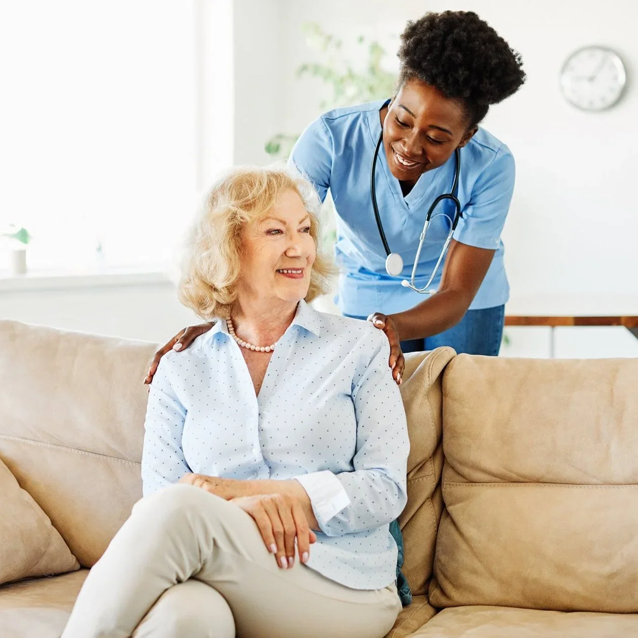 A nurse assists an older woman sitting on a couch | Feature image for the Nursing Assessments in Brisbane location page