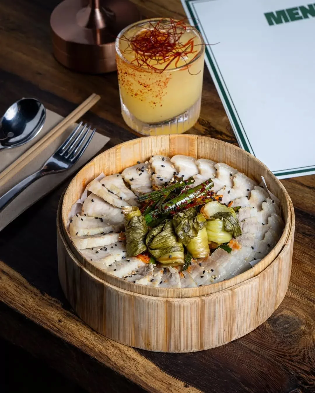 A Seoul Night essential. 🥢✨ Experience the balance of our slow-cooked Bossam. Savory pork belly meets the vibrant crunch of chive muchim and house-pickled bok choy. Authentic flavors, elevated atmosphere.