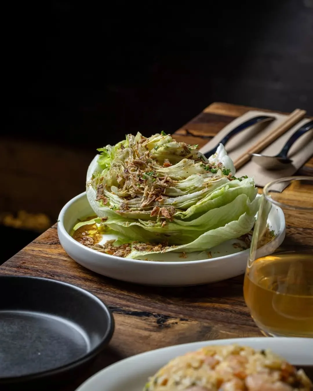 Crisp. Sharp. Essential. Iceberg wedge with sherry vinegar dressing, topped with fried shallots and parsley. The perfect sidekick to your Seoul Night favorites. 🥬