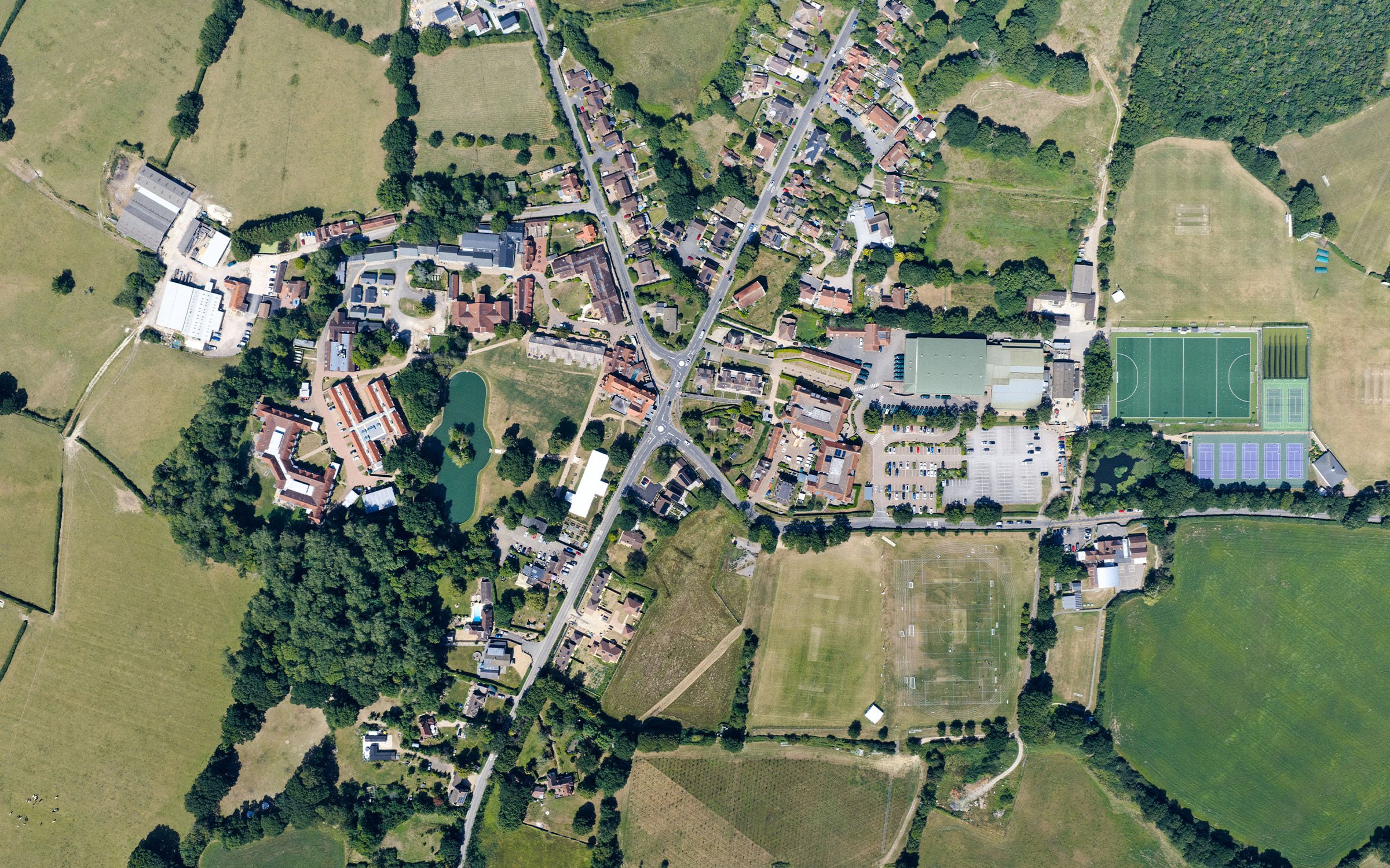 Vista aérea del campus de Dicker en East Sussex, con edificios, zonas verdes, campos deportivos y pistas de tenis.