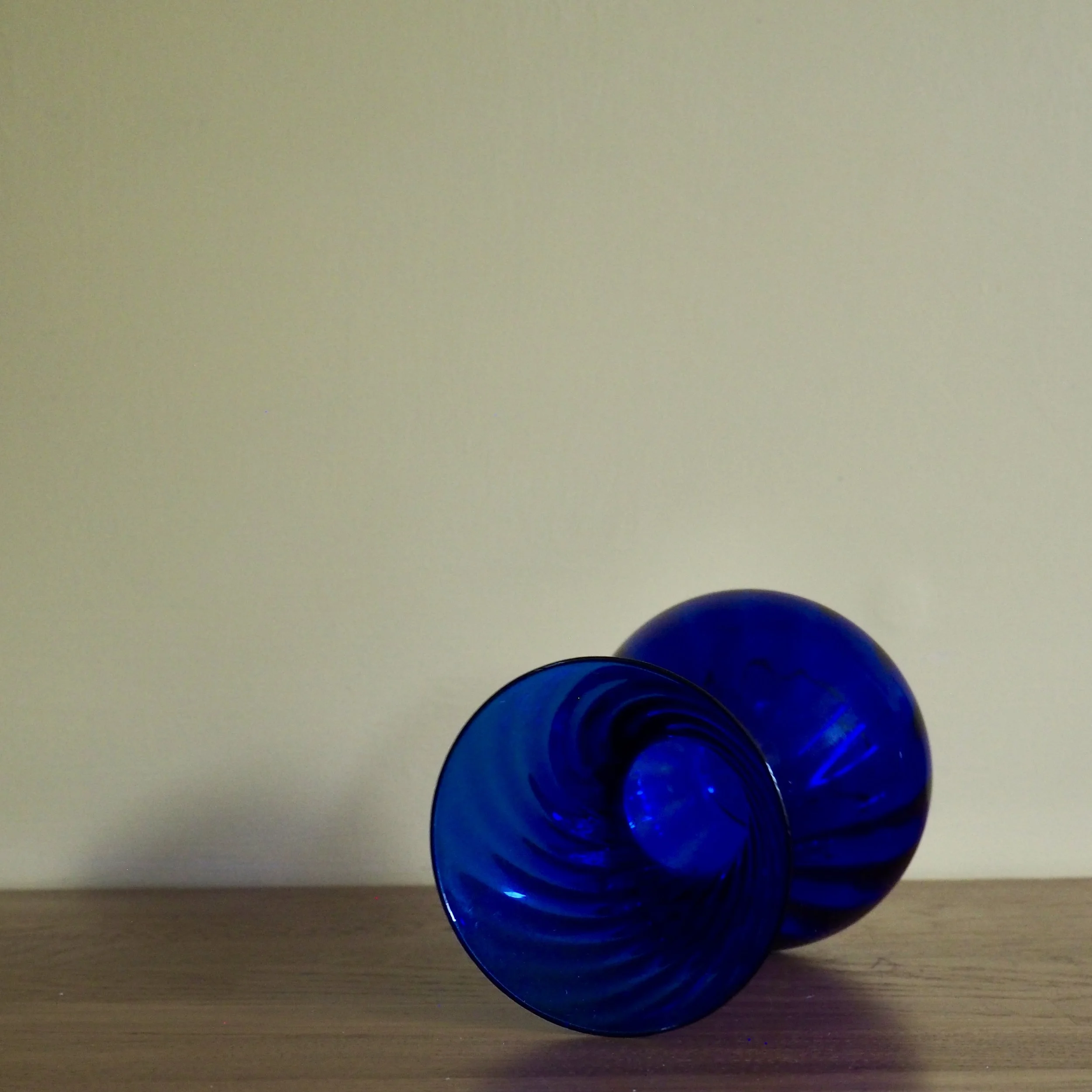 Deep blue vintage art glass vase with a twist pattern detail Vase lying in its side