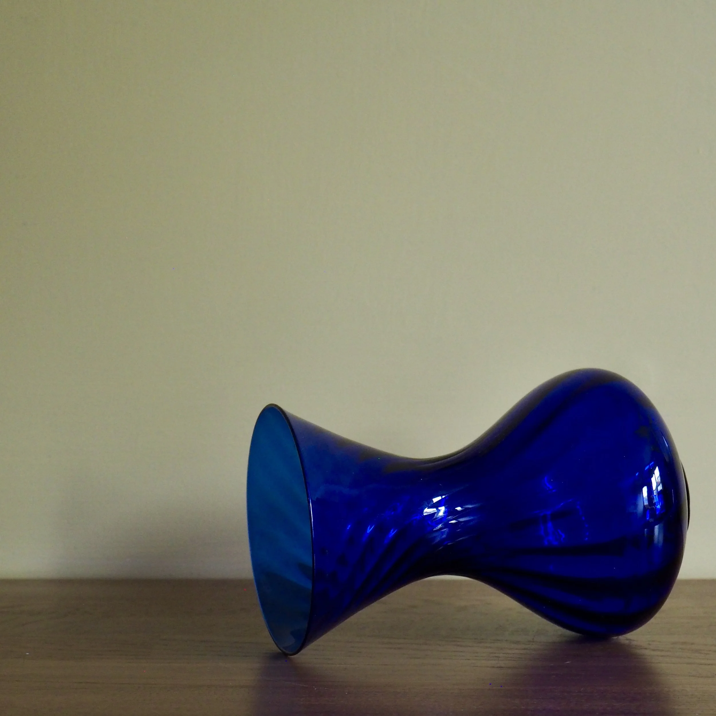Deep blue vintage art glass vase with a twist pattern detail Glass lying on its side
