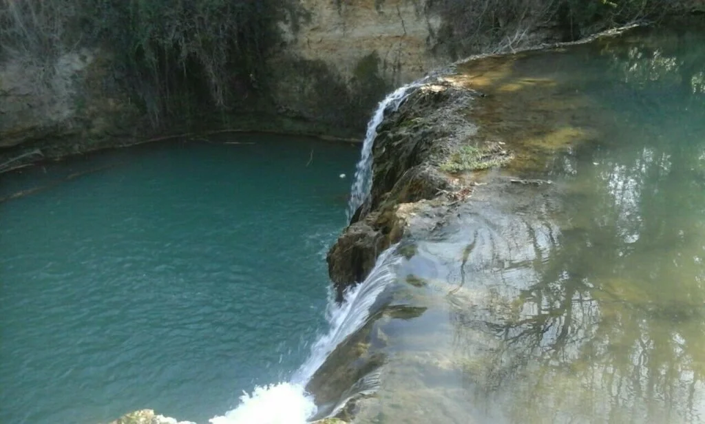 A_serene_waterfall_cascades_into_a_deep_turquoise_I82IyB8g.jpg