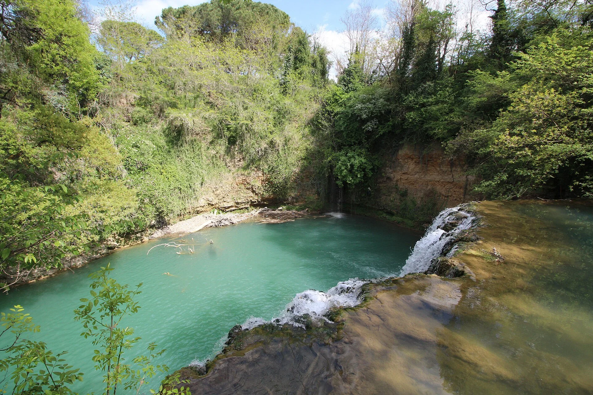 A_tranquil_turquoise_pool_is_fed_by_a_small_s7zjiUKX.jpg