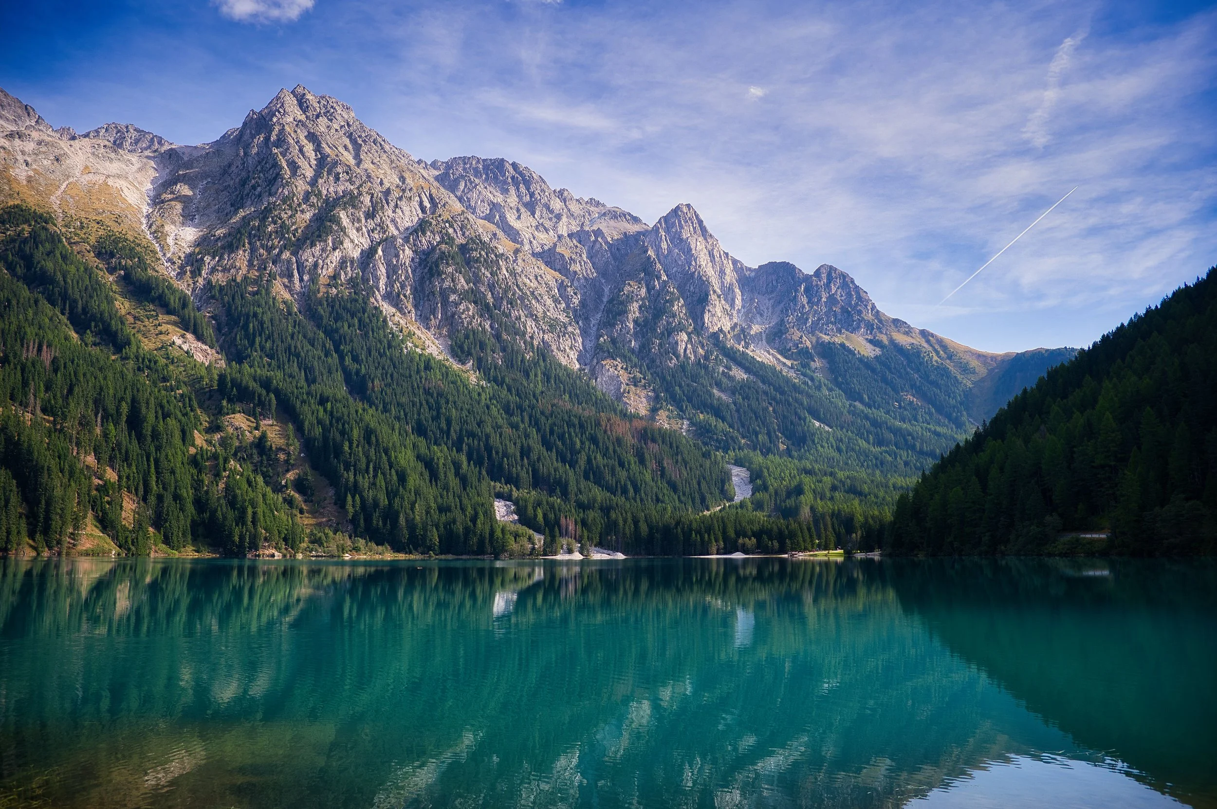AMICI_IN_VIAGGIO_CONTENT_A_serene_alpine_lake_reflects_the_imposing_rocky_WUR92UNc.jpg