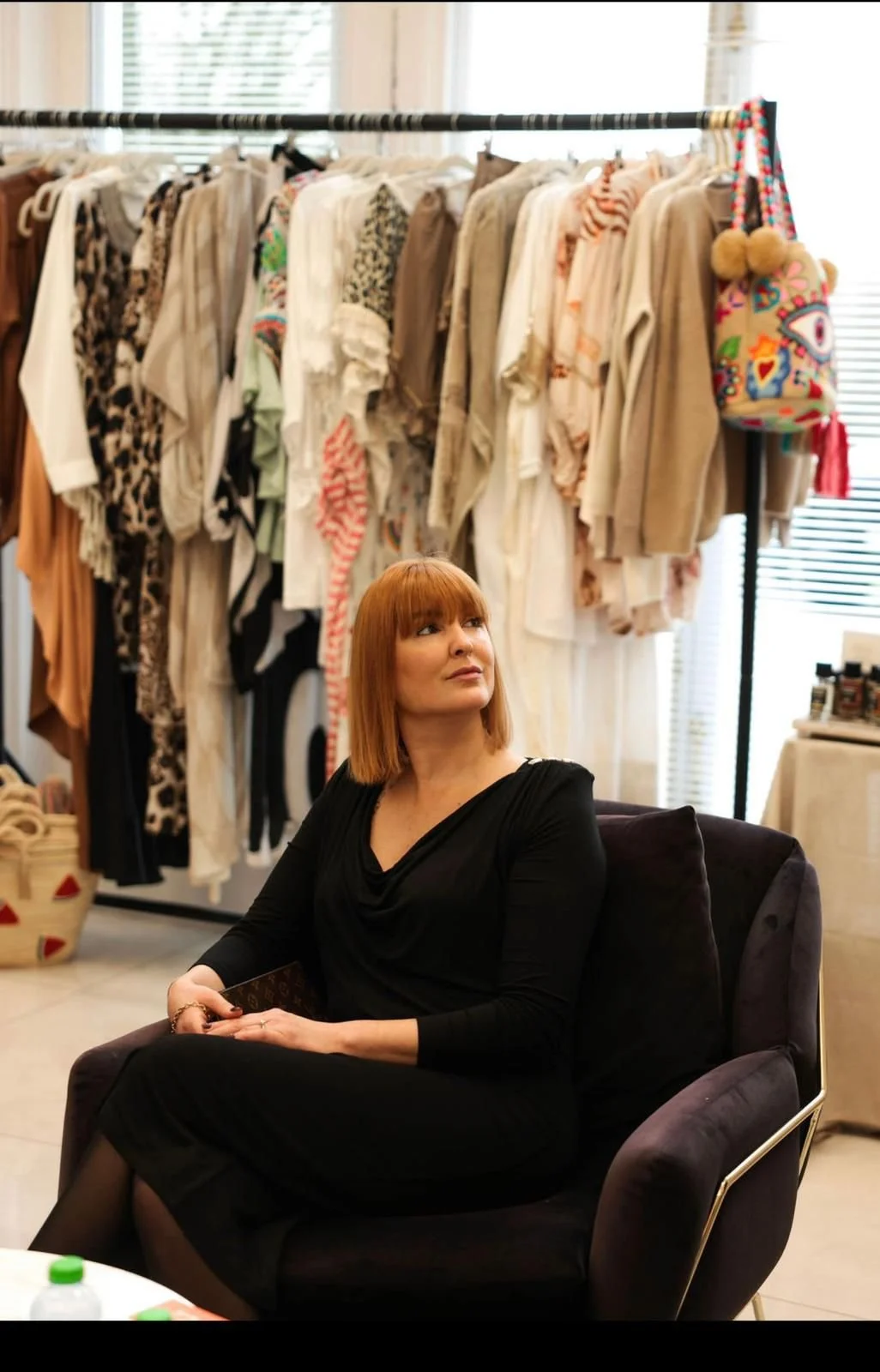 A family portrait featuring three adults and three children, with the family dressed in casual light-colored clothing, posing against a neutral background.