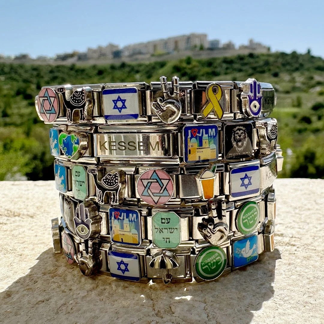 A stack of fabulous kessemi israeli charm bracelets featuring magen david, israeli flag, am yisrael chai