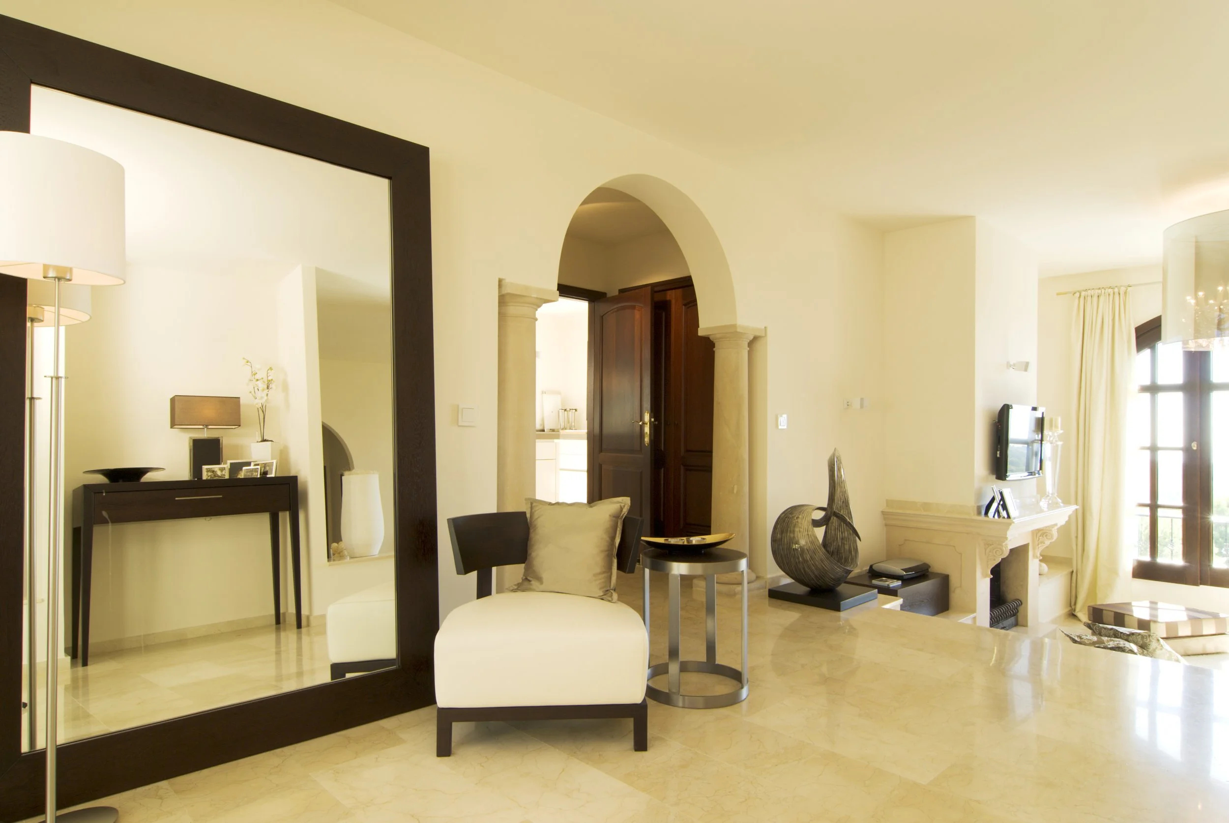 Innenaufnahme eines modernen, eleganten Wohnzimmers mit Sofas, Dekorationskunst und großen Fenstern, die viel Licht hereinlassen.