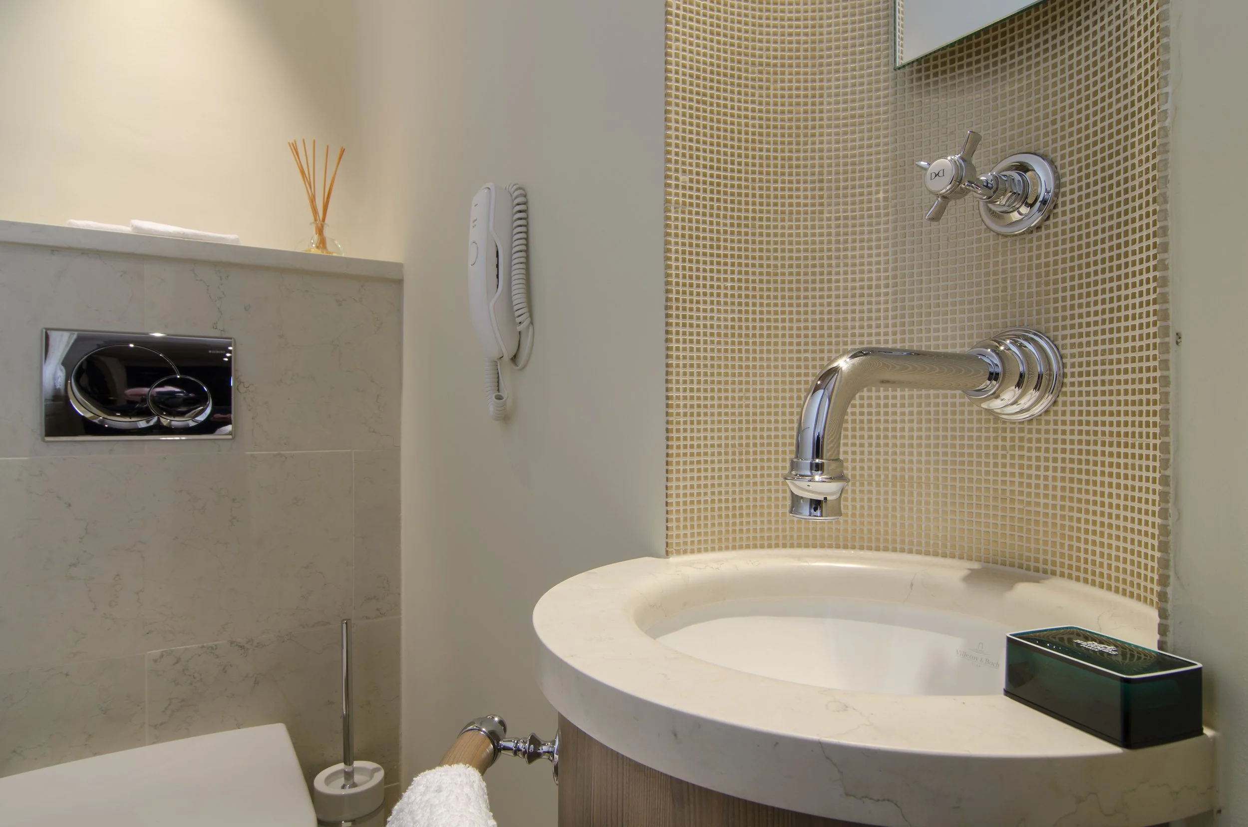 Badezimmer mit Waschbecken, Spiegel, Wasserhahn, Wassersteuerung, Telefon an der Wand, Seife auf dem Waschbecken, für Sauberkeit und Hygiene