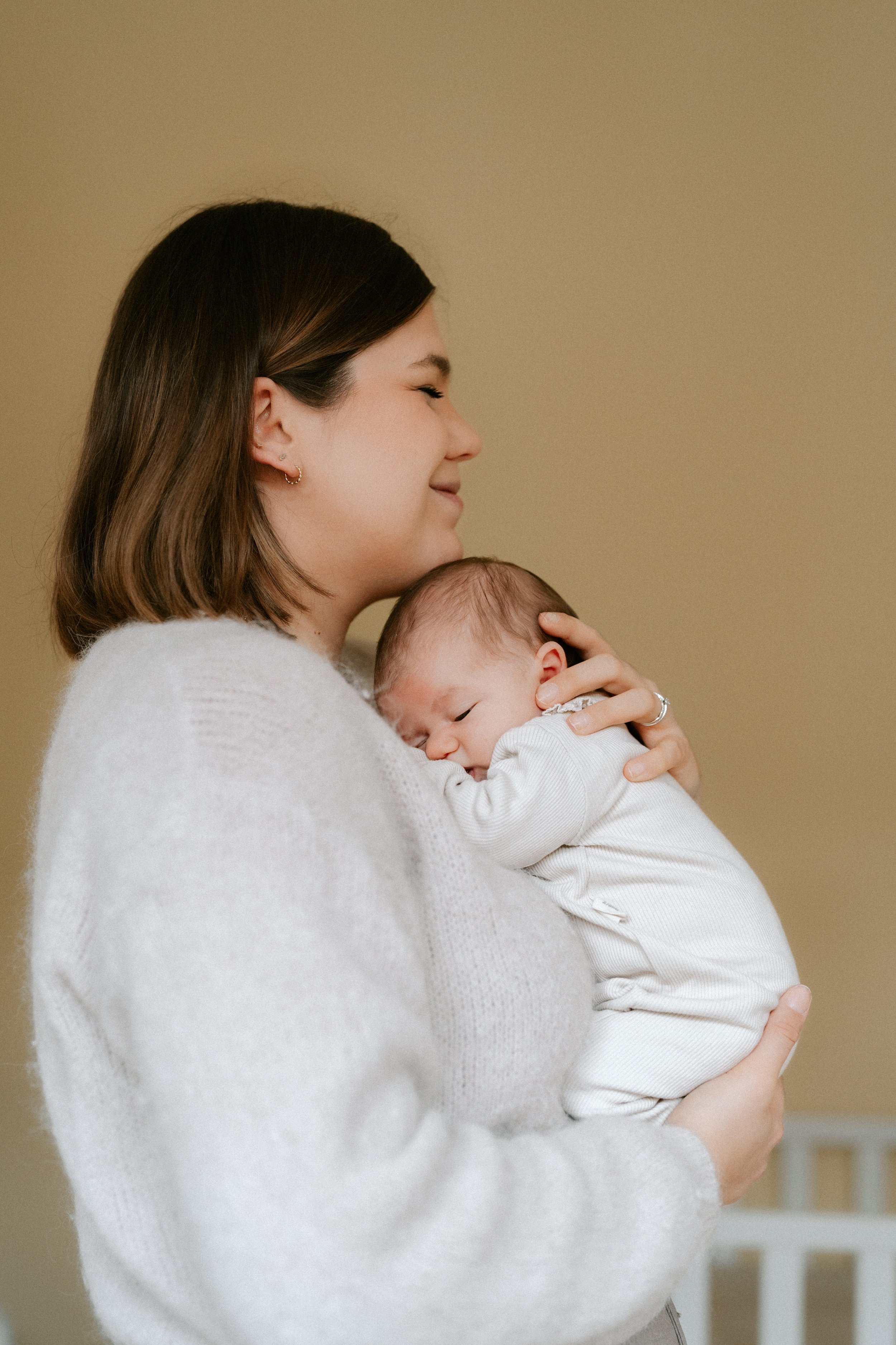 newborn resting against their mother’s chest at home