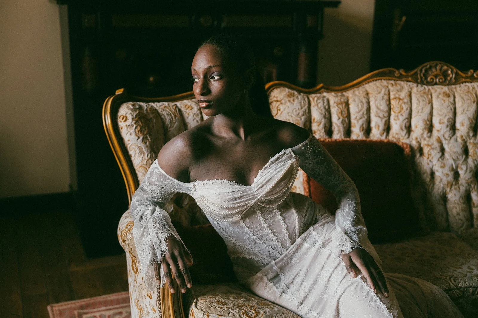 black woman in renaissance sofa during soft boudoir photoshoot
