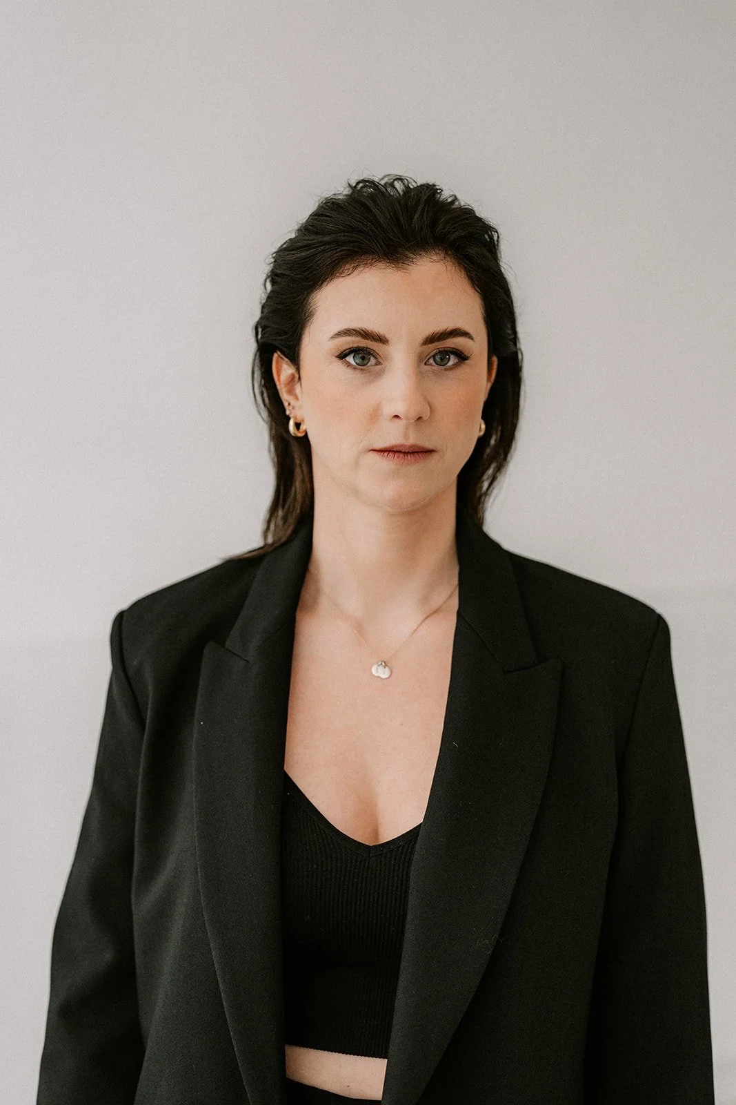 Minimal branding portrait of a female entrepreneur in a studio with soft natural light