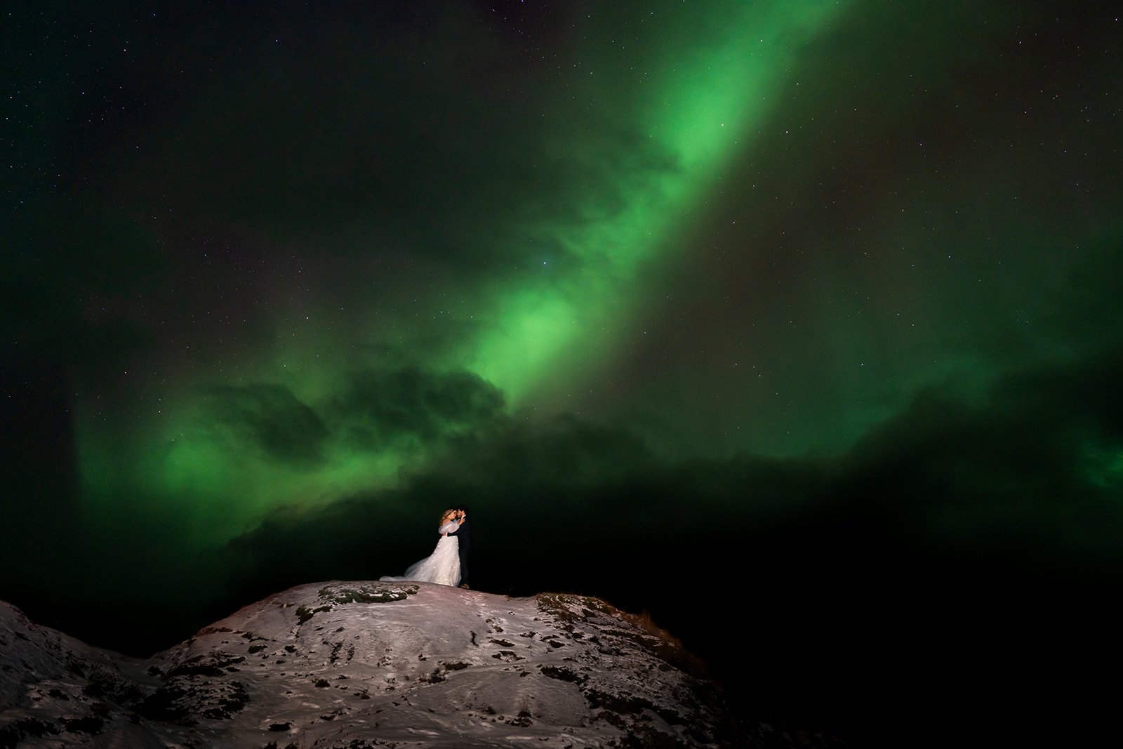 wedding couple standing under the northern lights in Norway 