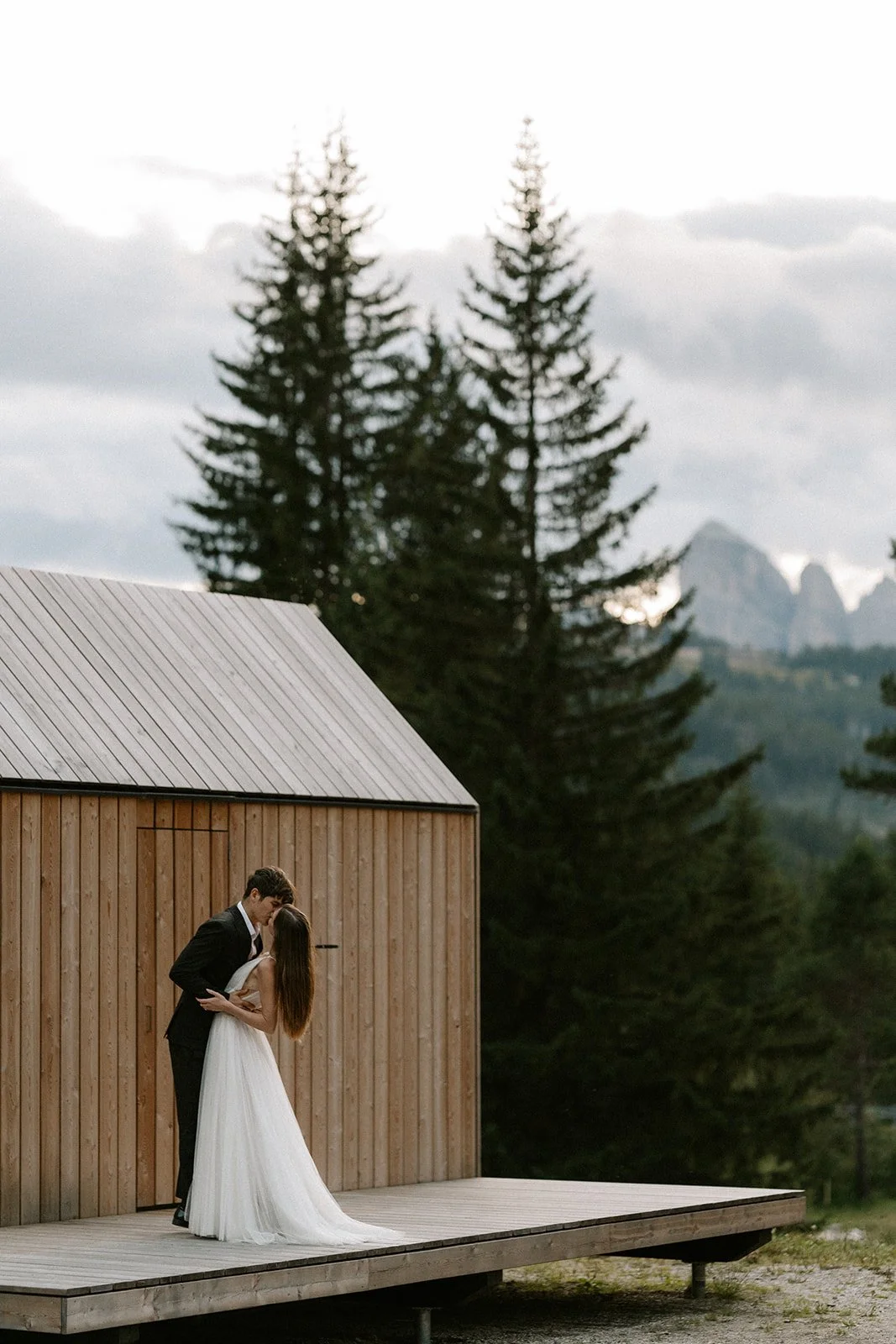 Couple embracing outside a mountain chalet during a Dolomites elopement