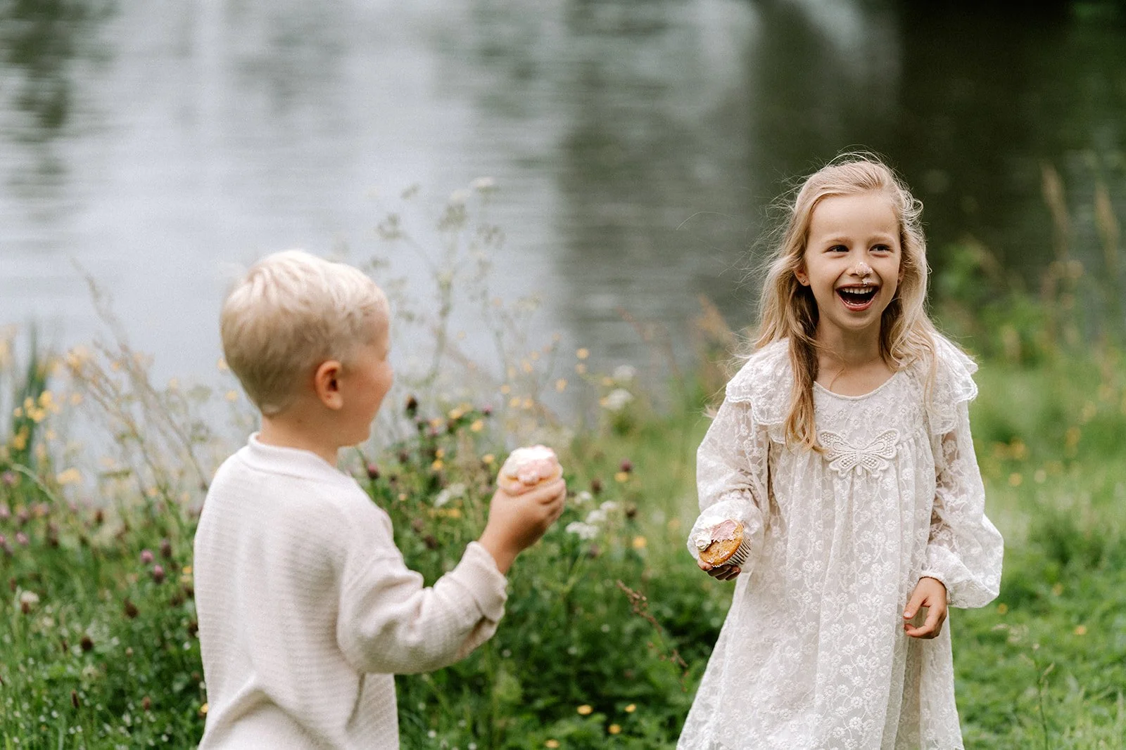Broer en zus hebben plezier aan de vijver tijdens een spontane familieshoot nabij Oudenaarde.