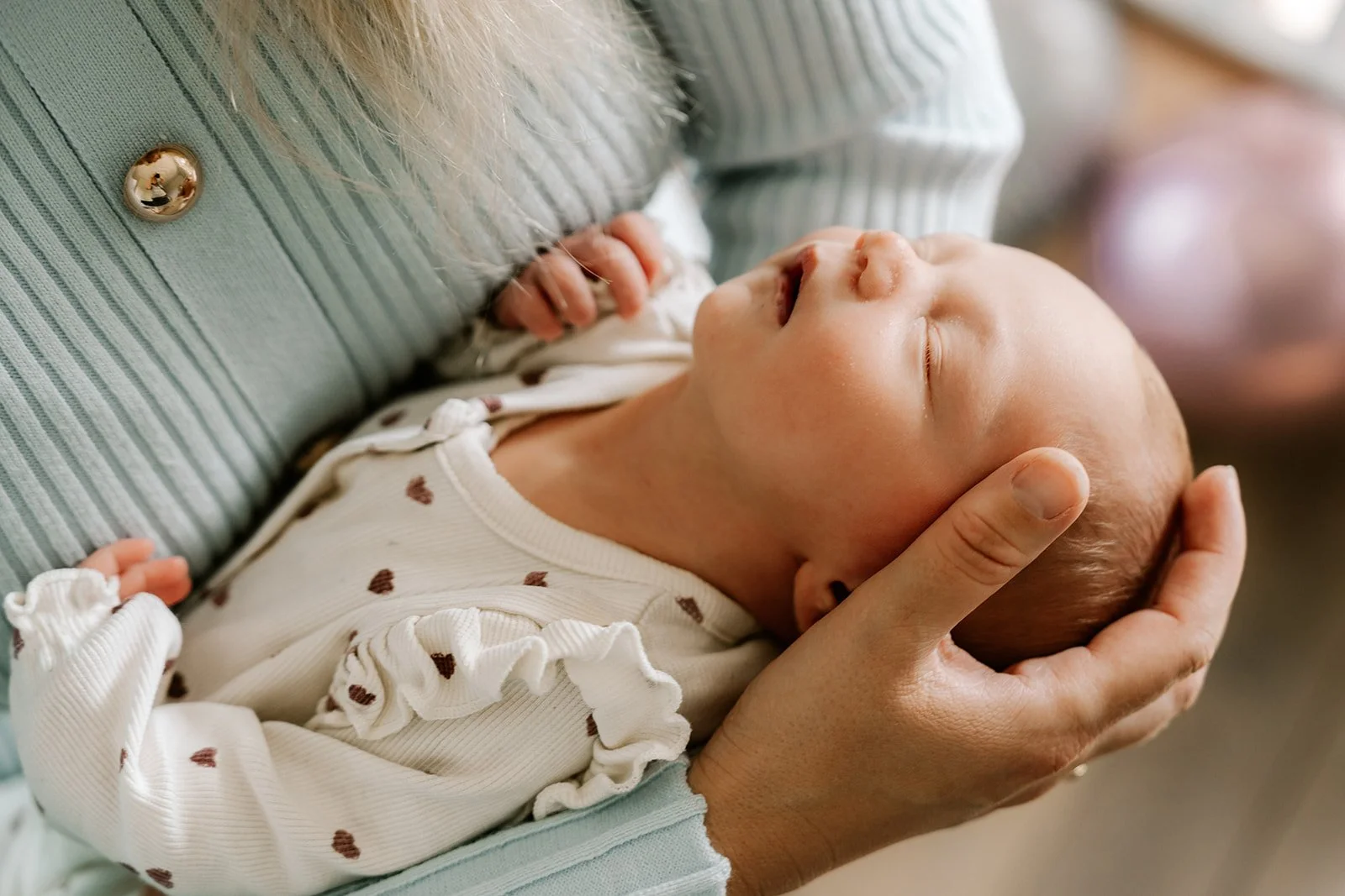 newborn baby ligt rustig te slapen in mama's armen