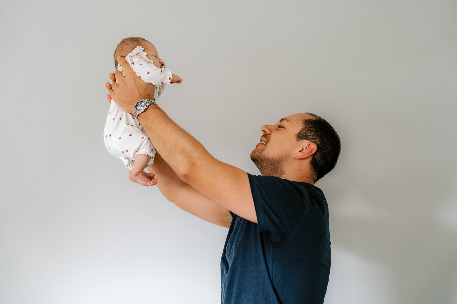 papa doet de leeuwenkoning na en houdt pasgeboren dochter hoog in de lucht