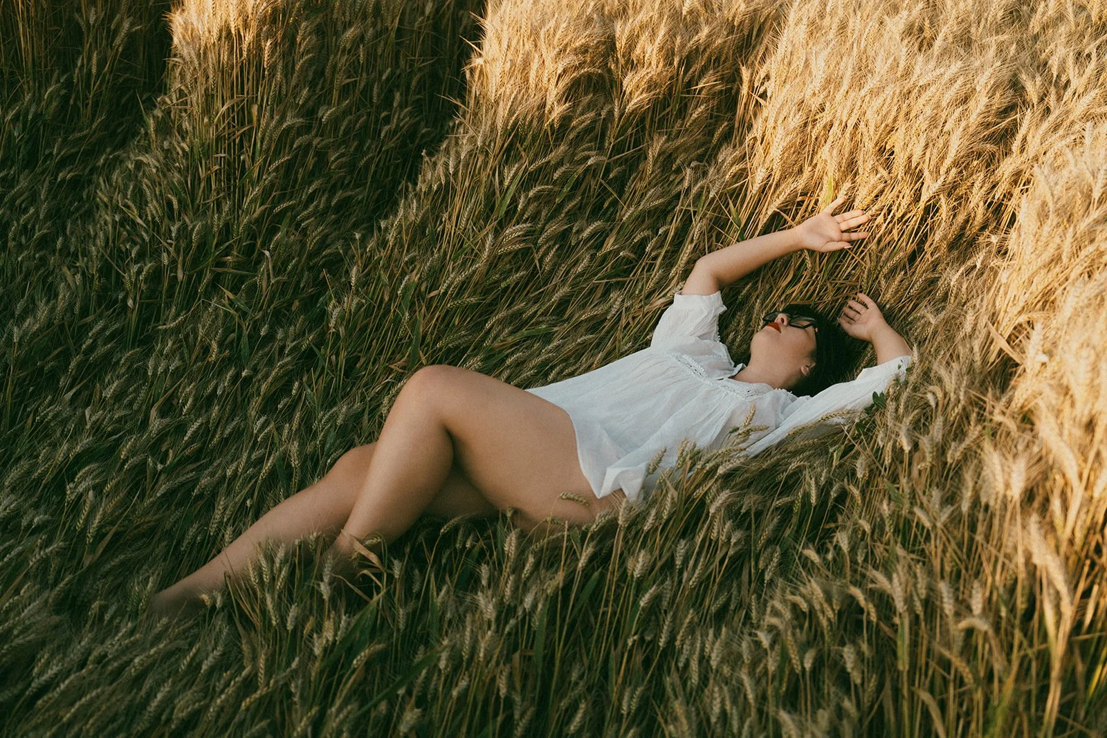 Soft light on woman laying in the grass during boudoir photoshoot