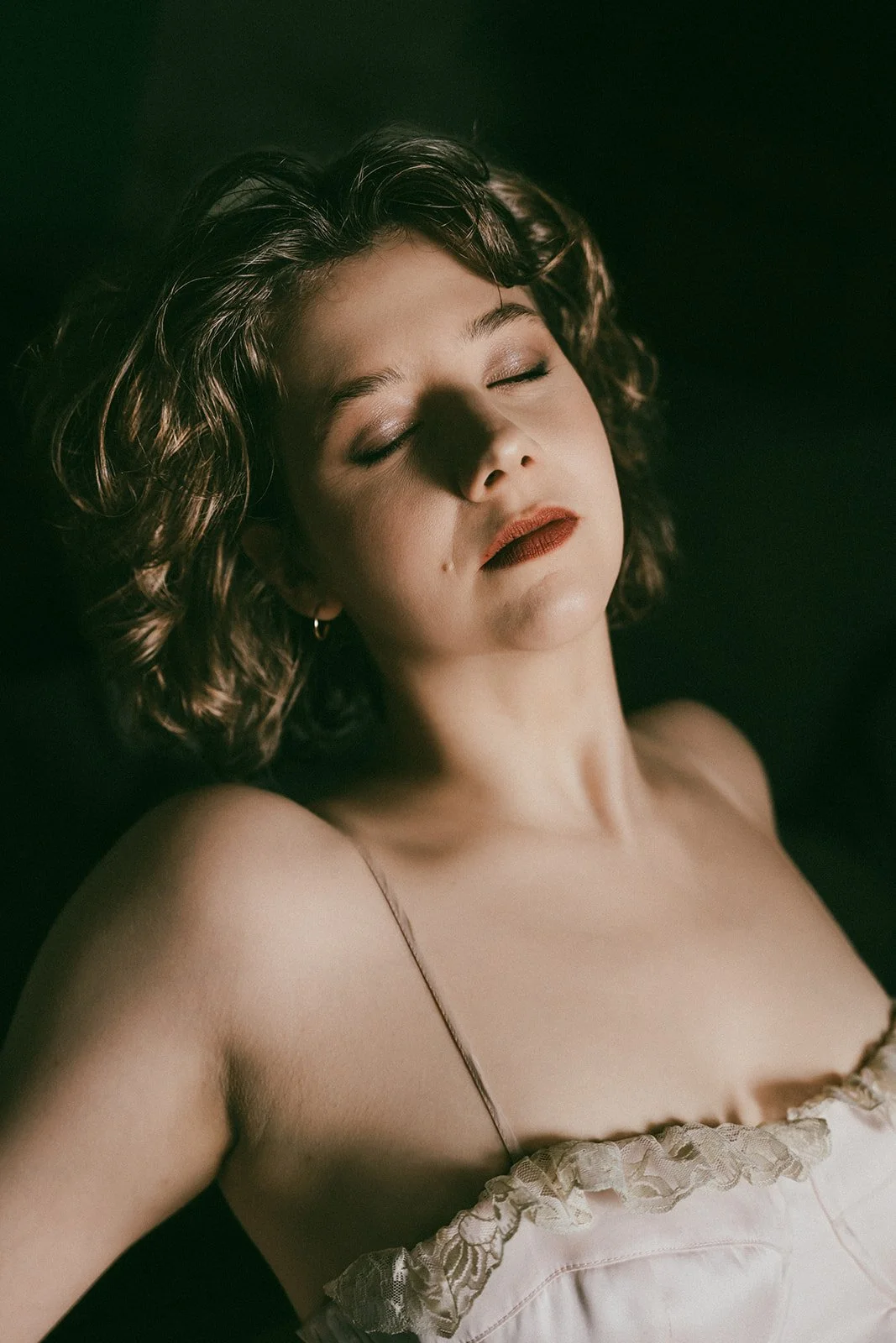 woman closing her eyes during a soft boudoir photoshoot