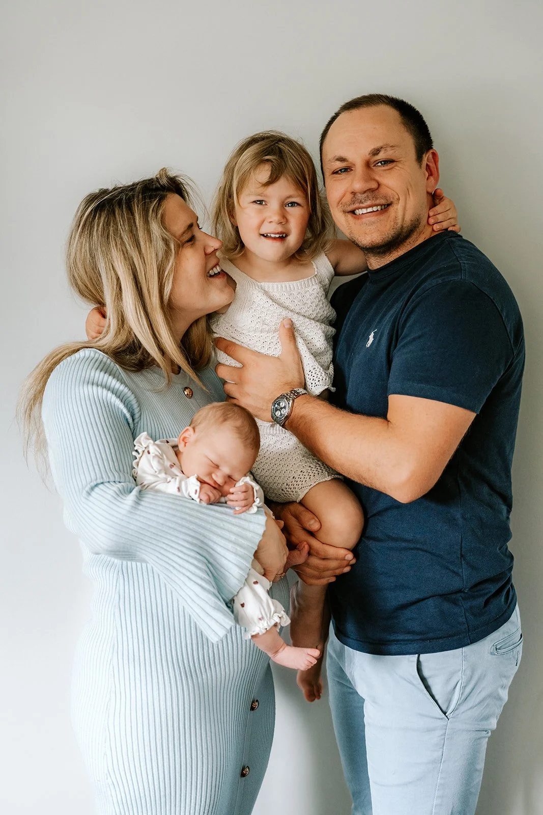 Gezin van vier samen tijdens een ontspannen newborn fotoshoot.