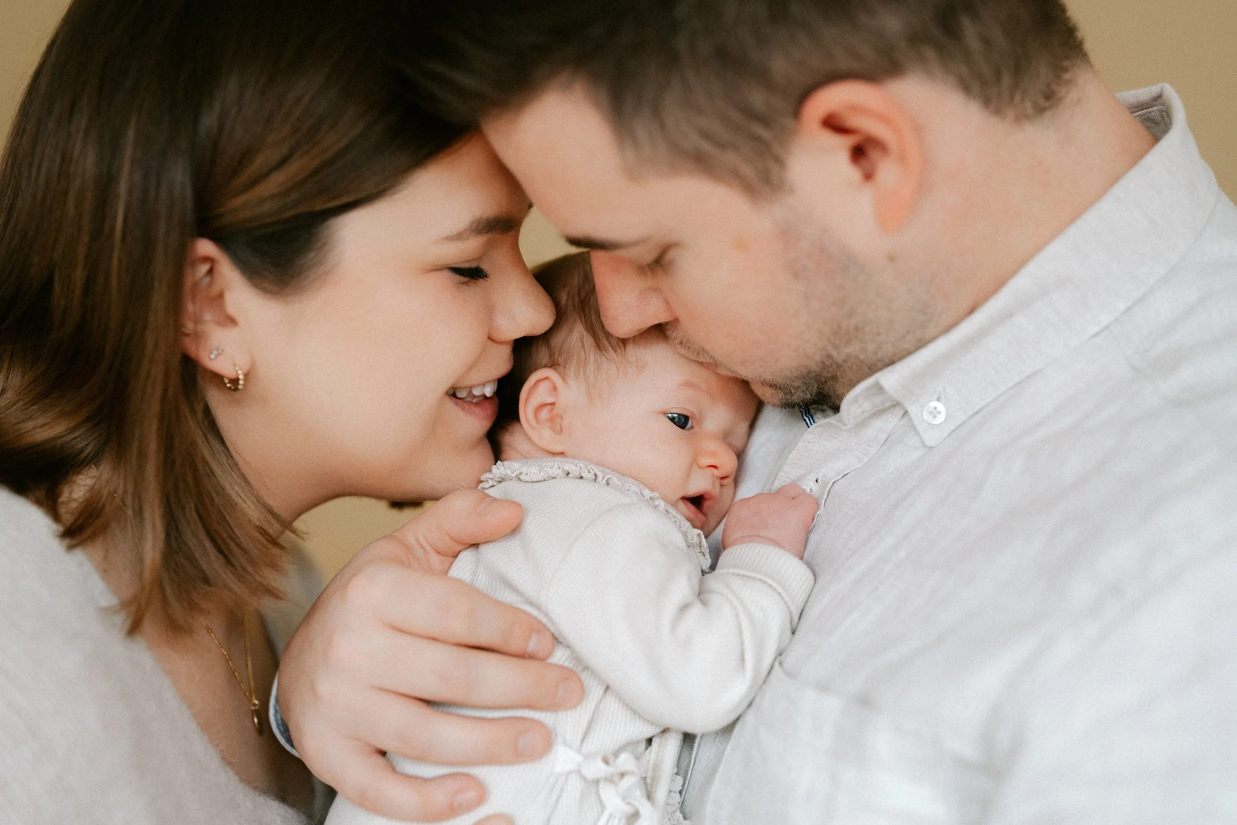 parents cuddling their newborn in their own living space