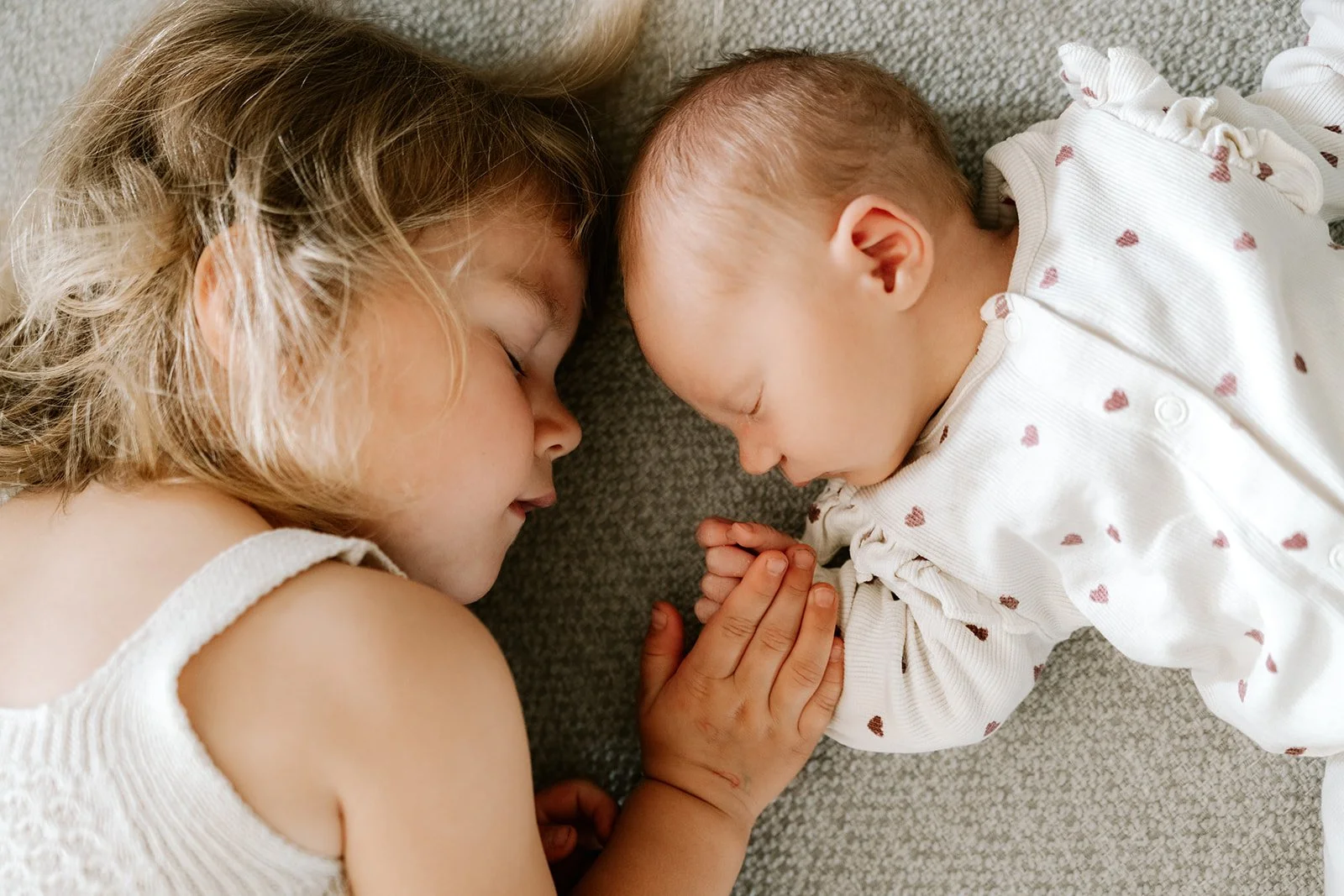 liefdevol moment tussen grote zus en kleine zus in de zetel
