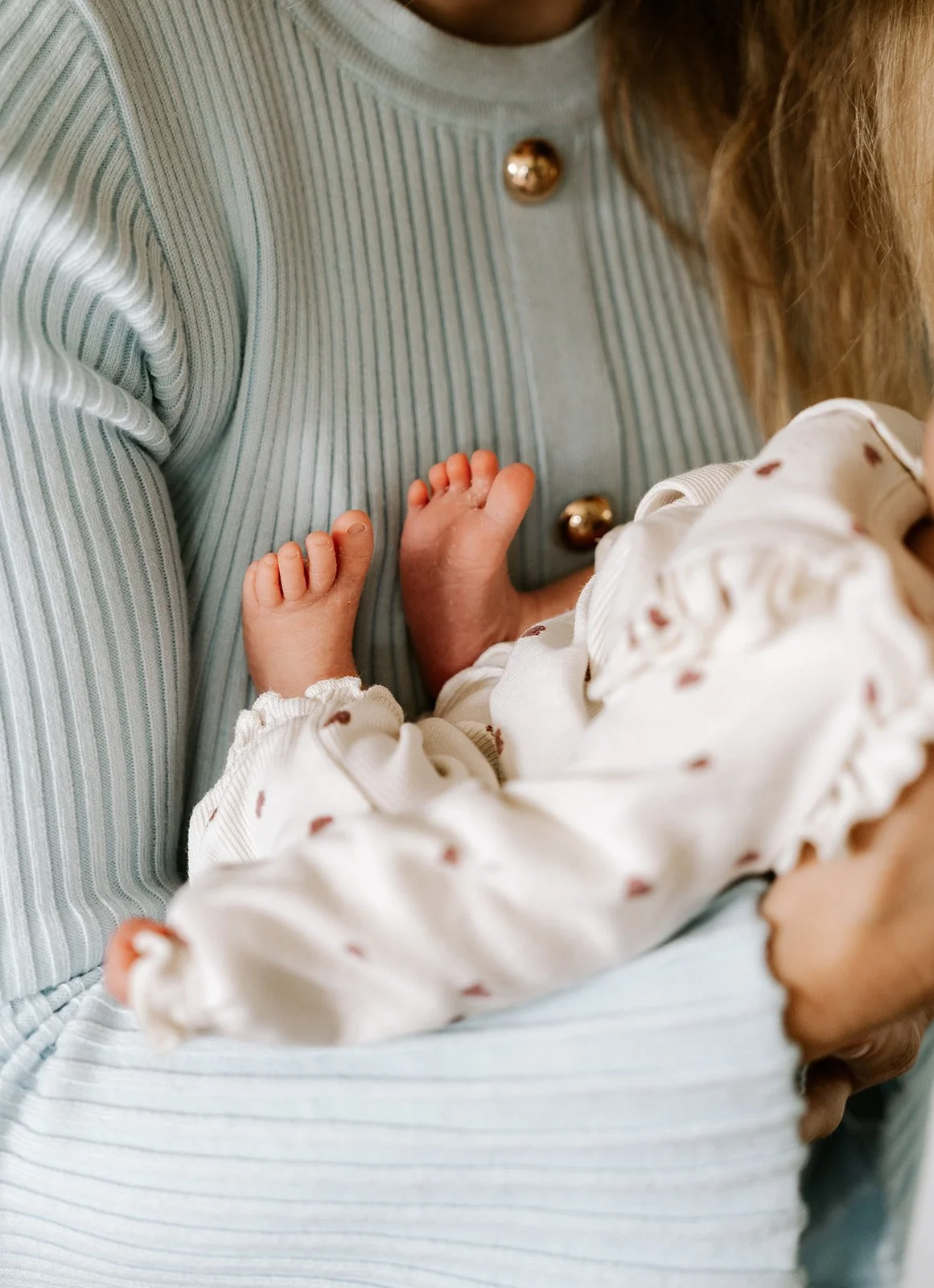 foto van de voetjes van een Newborn baby in mama's armen