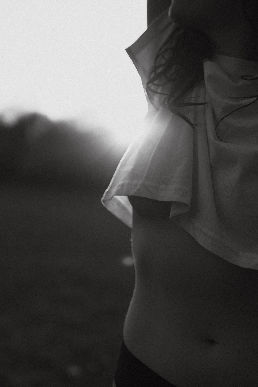 outdoor boudoir portrait of a woman in an open field, photographed during sunset in Belgium