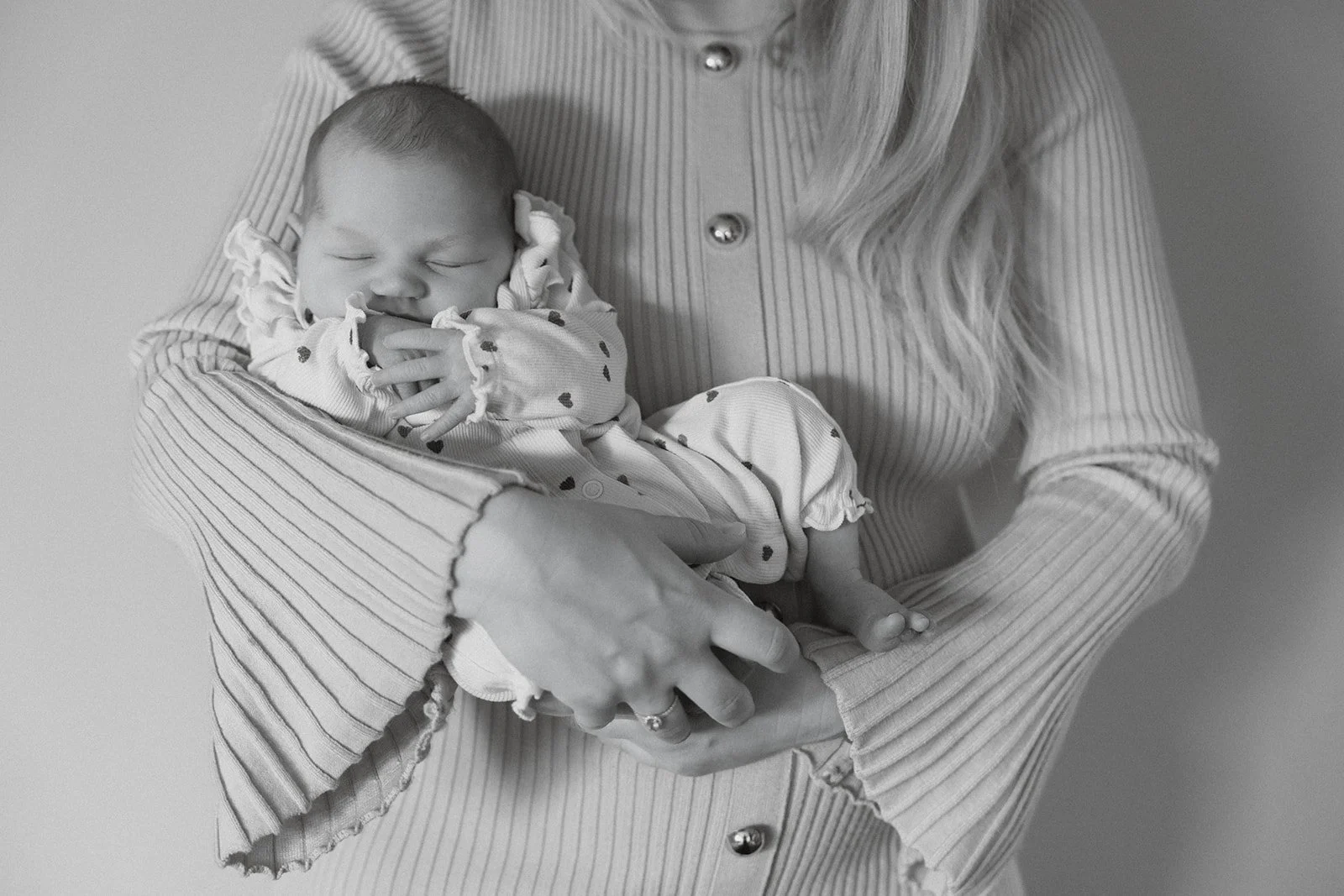 Mama houdt haar pasgeboren baby dicht tegen zich aan tijdens een rustige ochtend thuis.