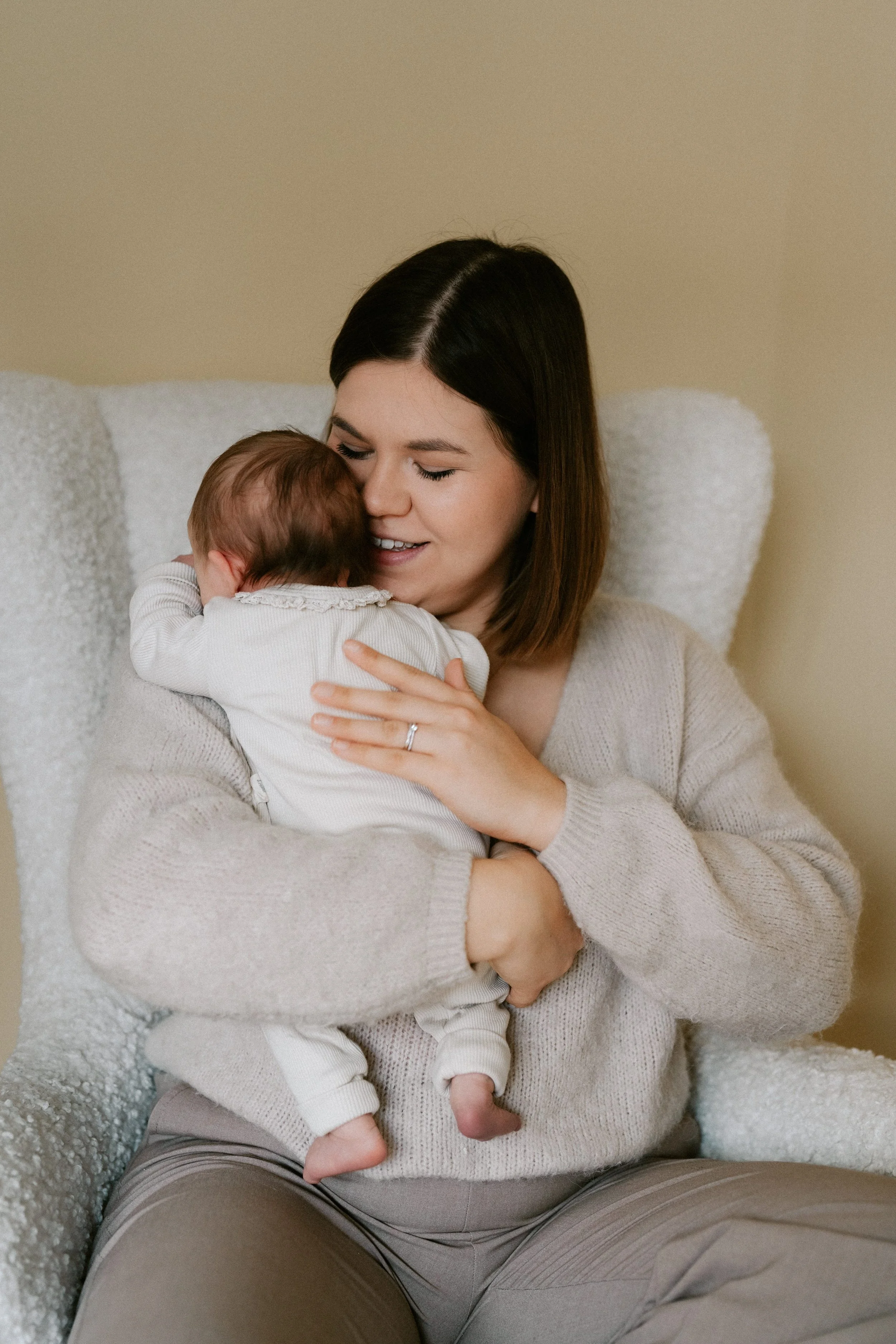 mother gently rocking her newborn in the nursing room