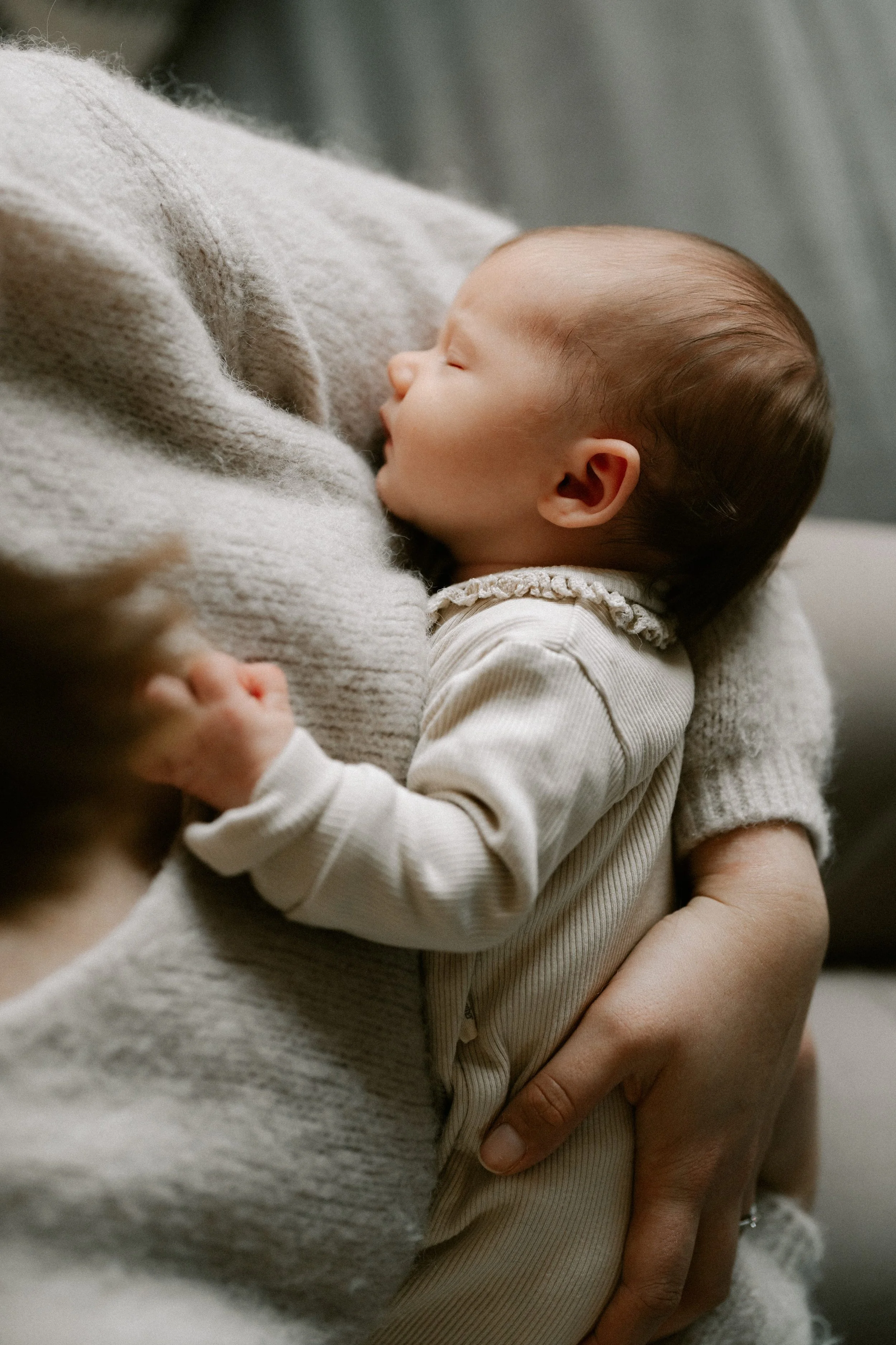 mother holding her newborn during an in-home photoshoot