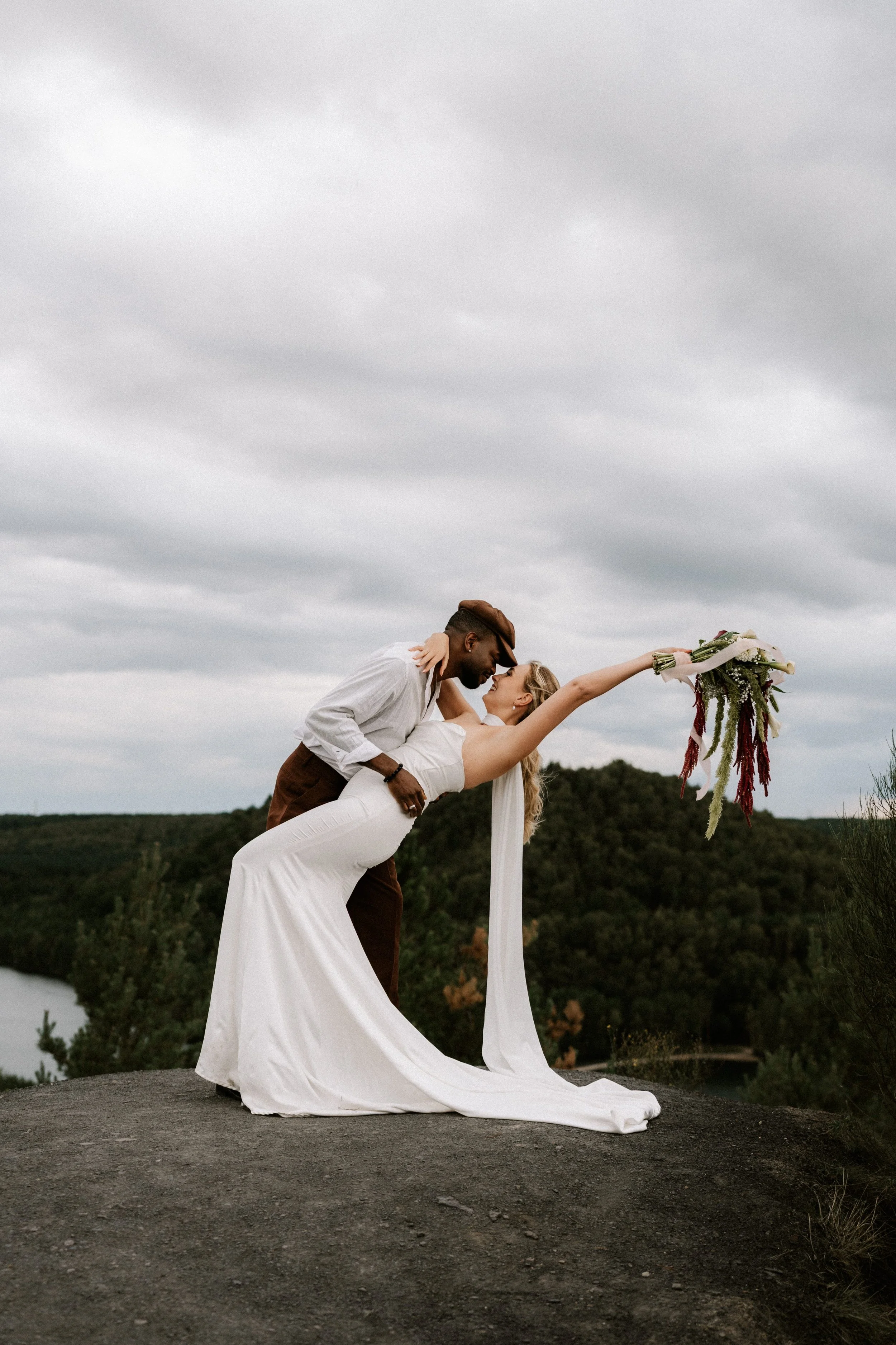 mixed race couple doing a dip kiss during intimate elopement in nature