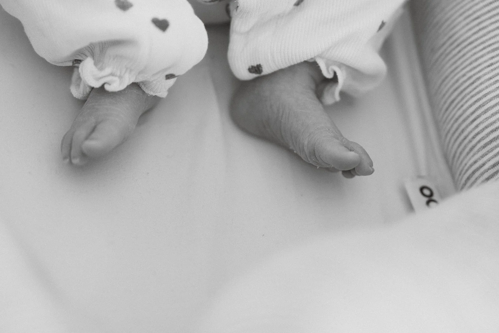 Detailfoto van kleine voetjes tijdens een newborn sessie in de vertrouwde thuisomgeving.