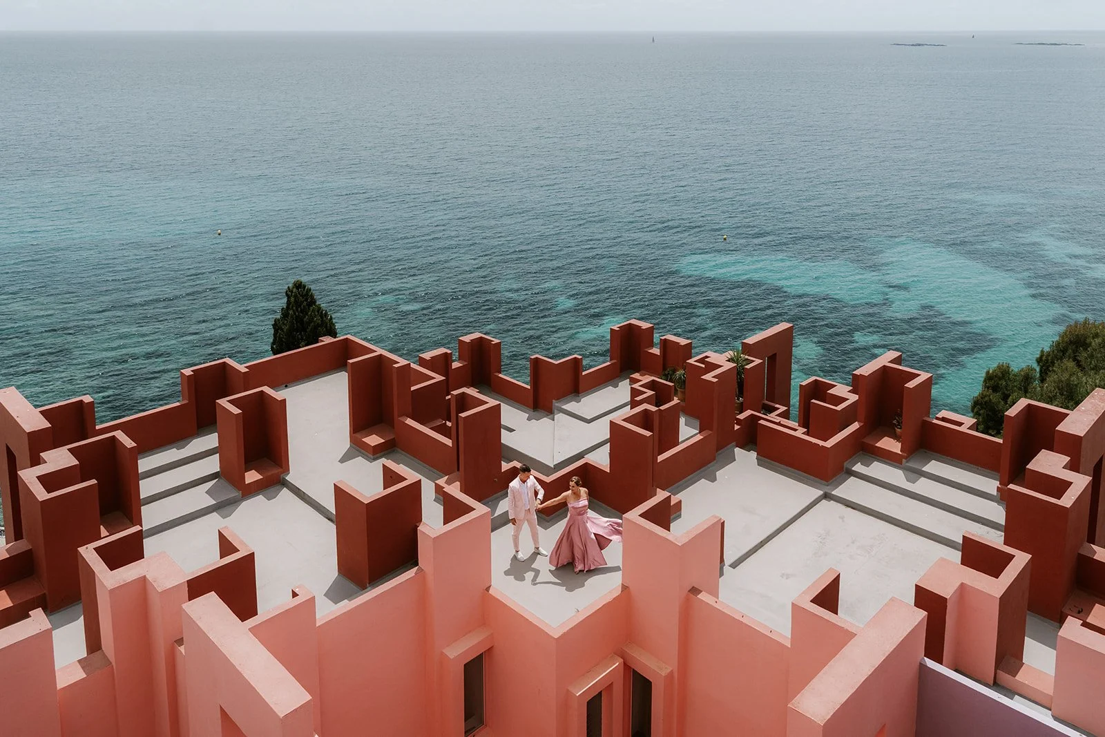 couple standing on top of the muralla roja in cape, spain